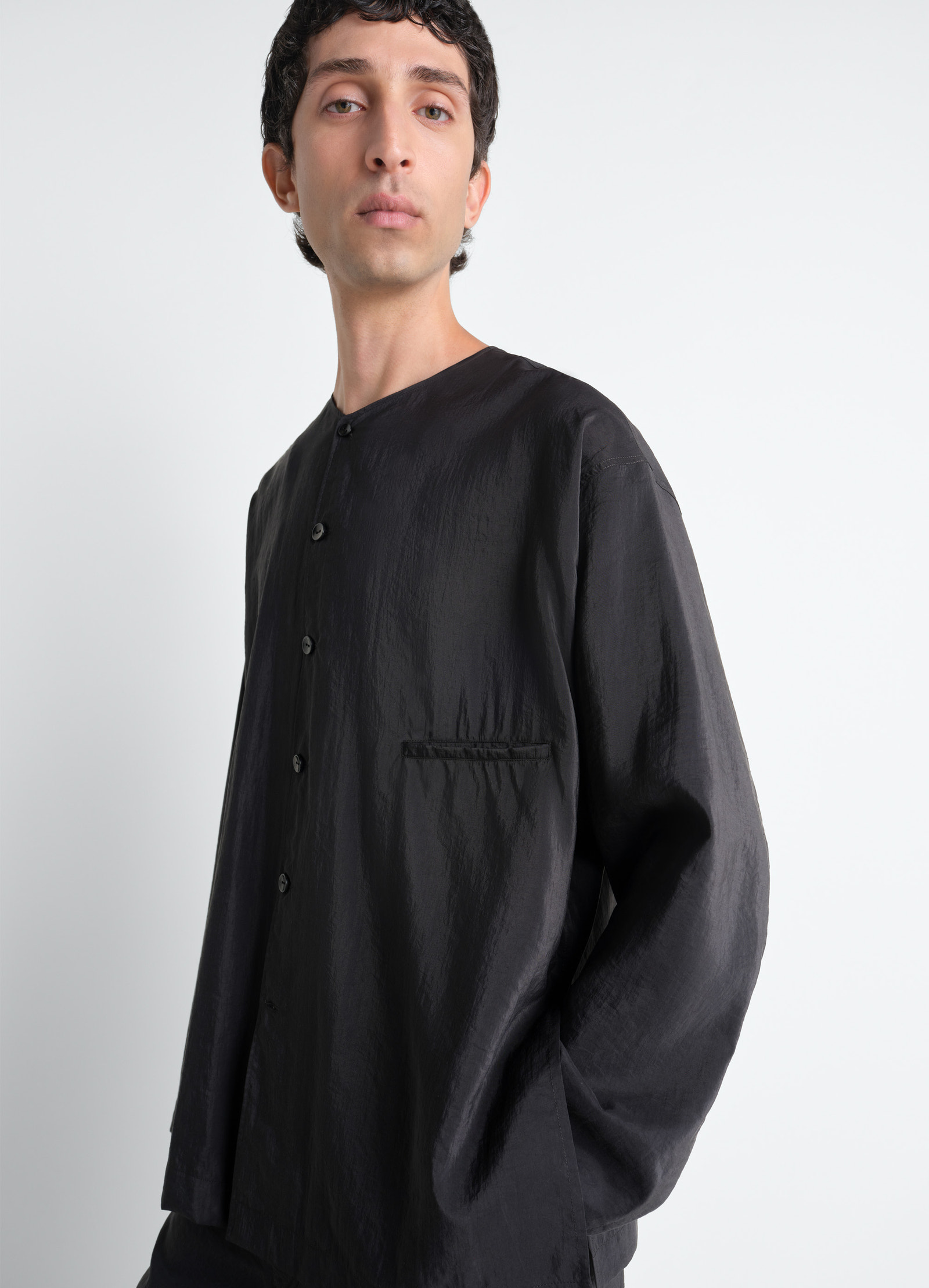 Lemaire v-neck shirt in black dry silk, model shot, close-up side view single chest pocket