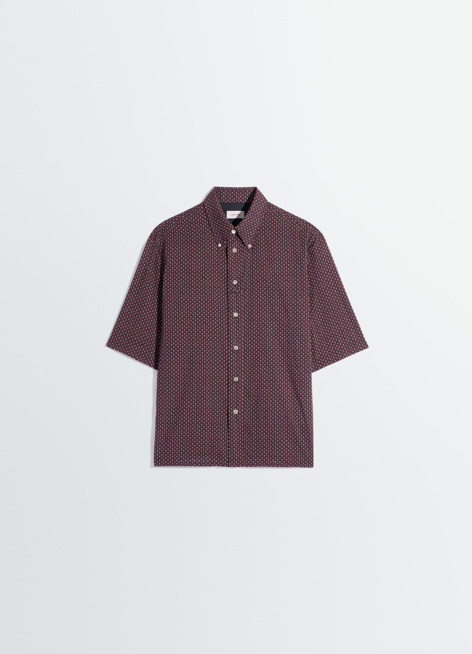 Lemaire short sleeve shirt in geometric printed cotton, product shot, angled overhead view straight hemline design