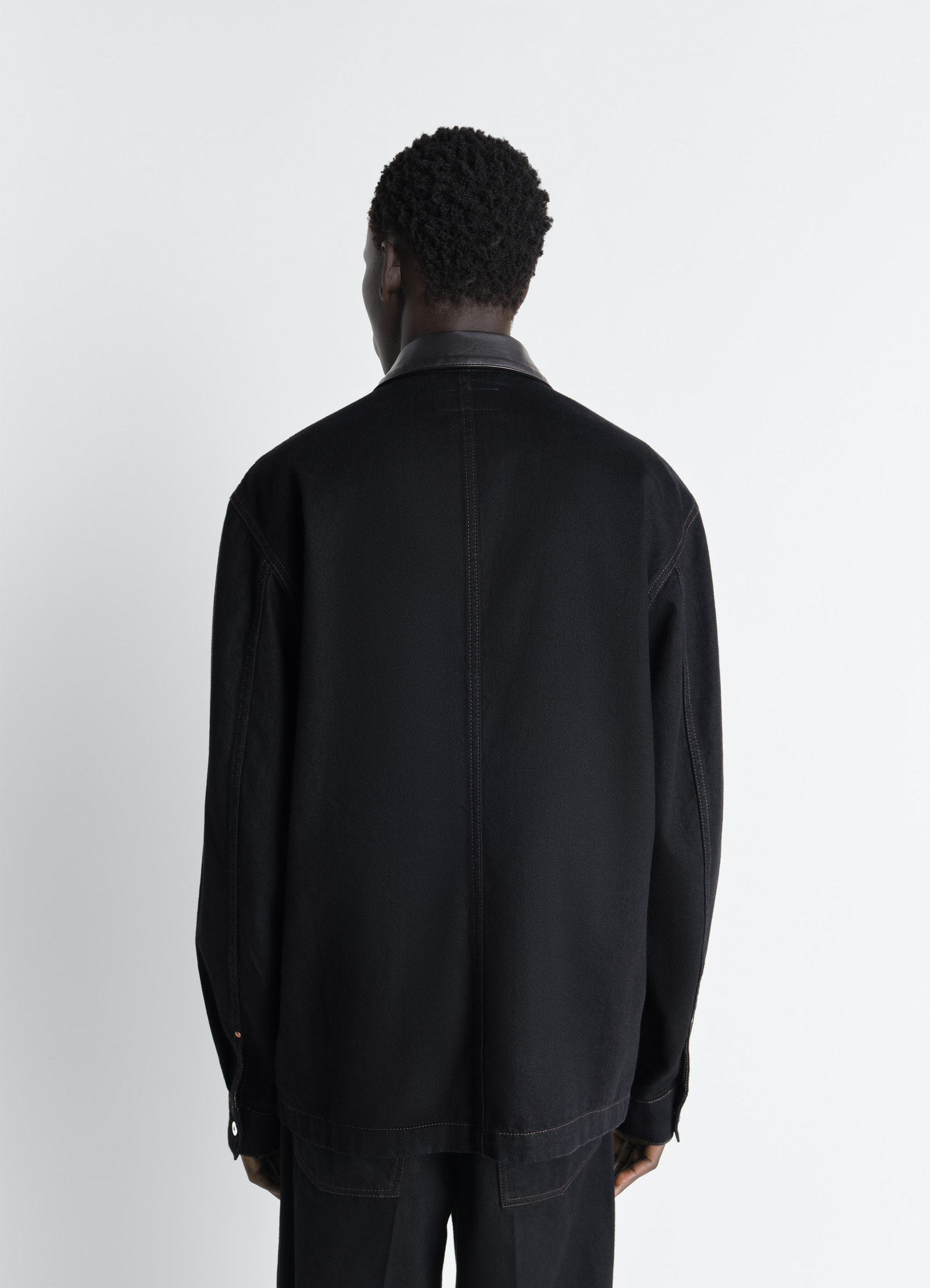 Workwear overshirt with leather col in black denim and leather, model shot, back view relaxed fit with leather collar