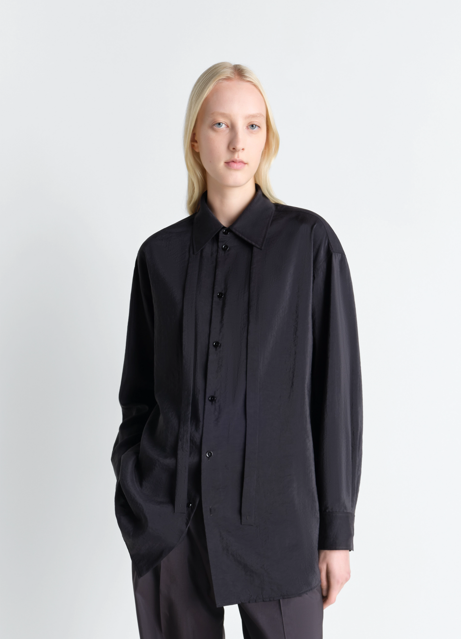 Lemaire long shirt with tie in black dry silk blend, model shot, three-quarter view relaxed buttoned fit