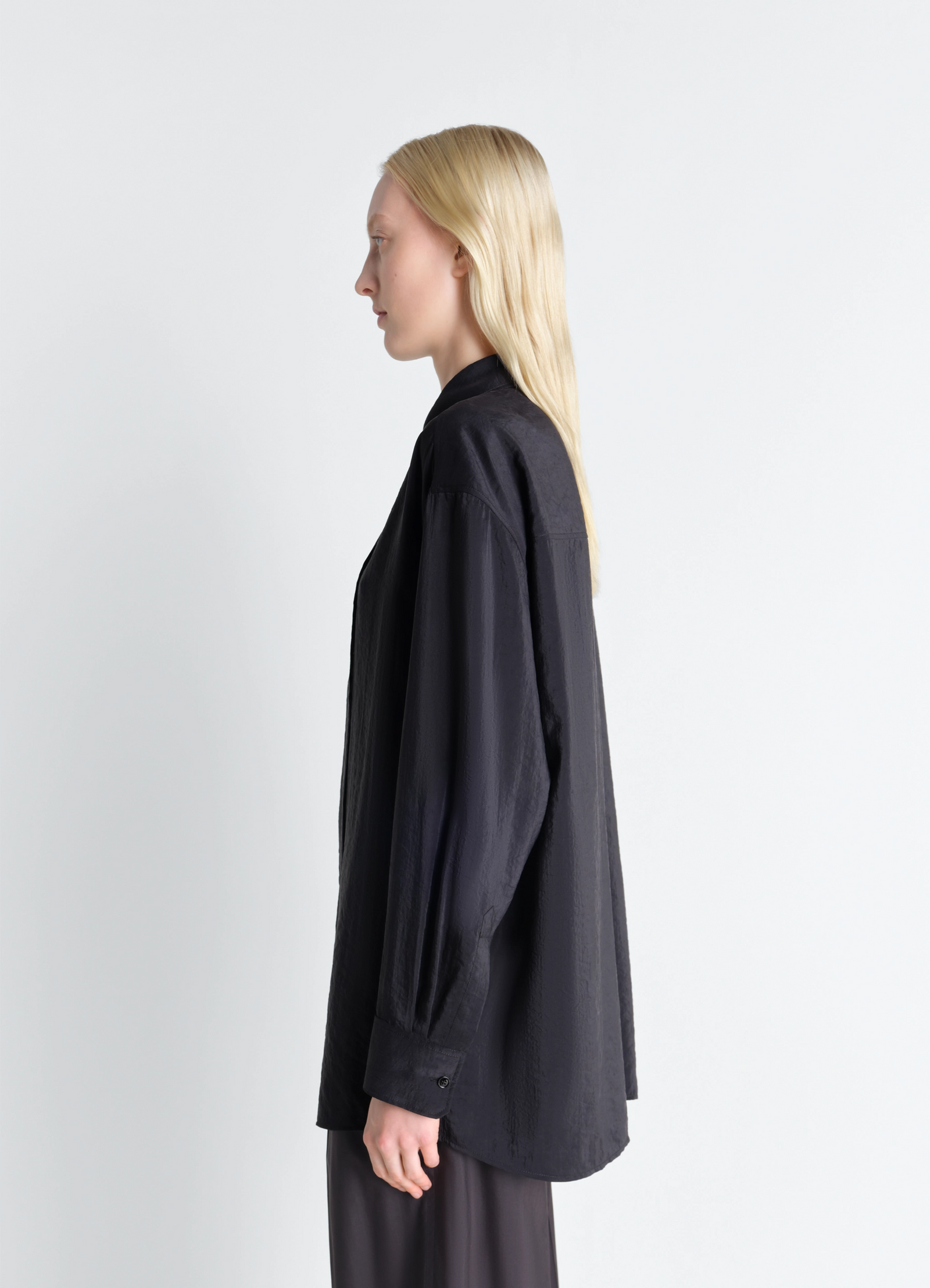 Lemaire long shirt with tie in black dry silk blend, model shot, side profile view loose cuffed sleeves