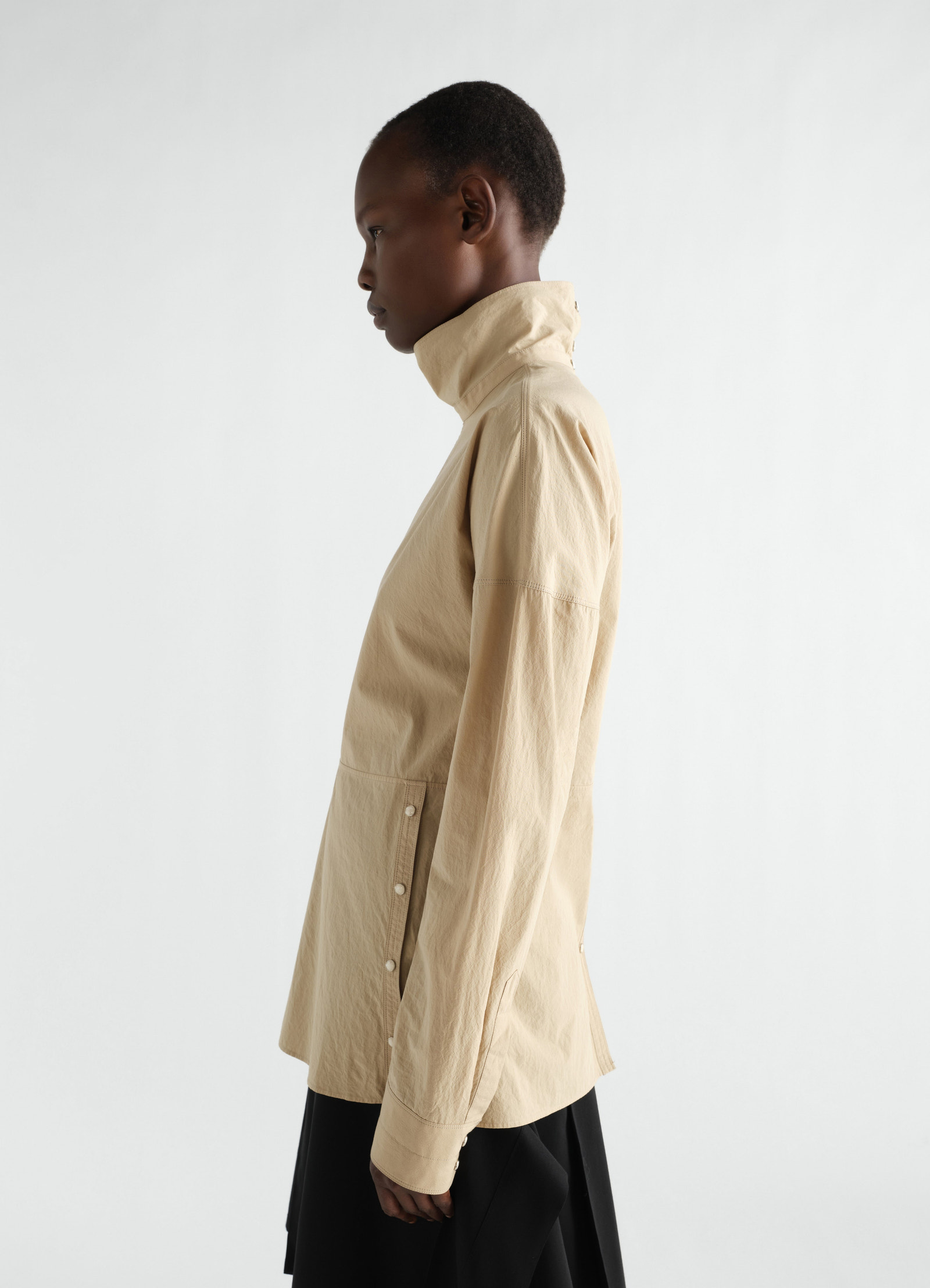 Press-stud bib top lemaire in beige cotton crepe side view worn by model with high collar and button details