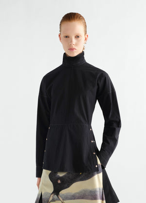 Press-stud bib top in black cotton crepe by lemaire worn by a model front view with high collar and side snaps