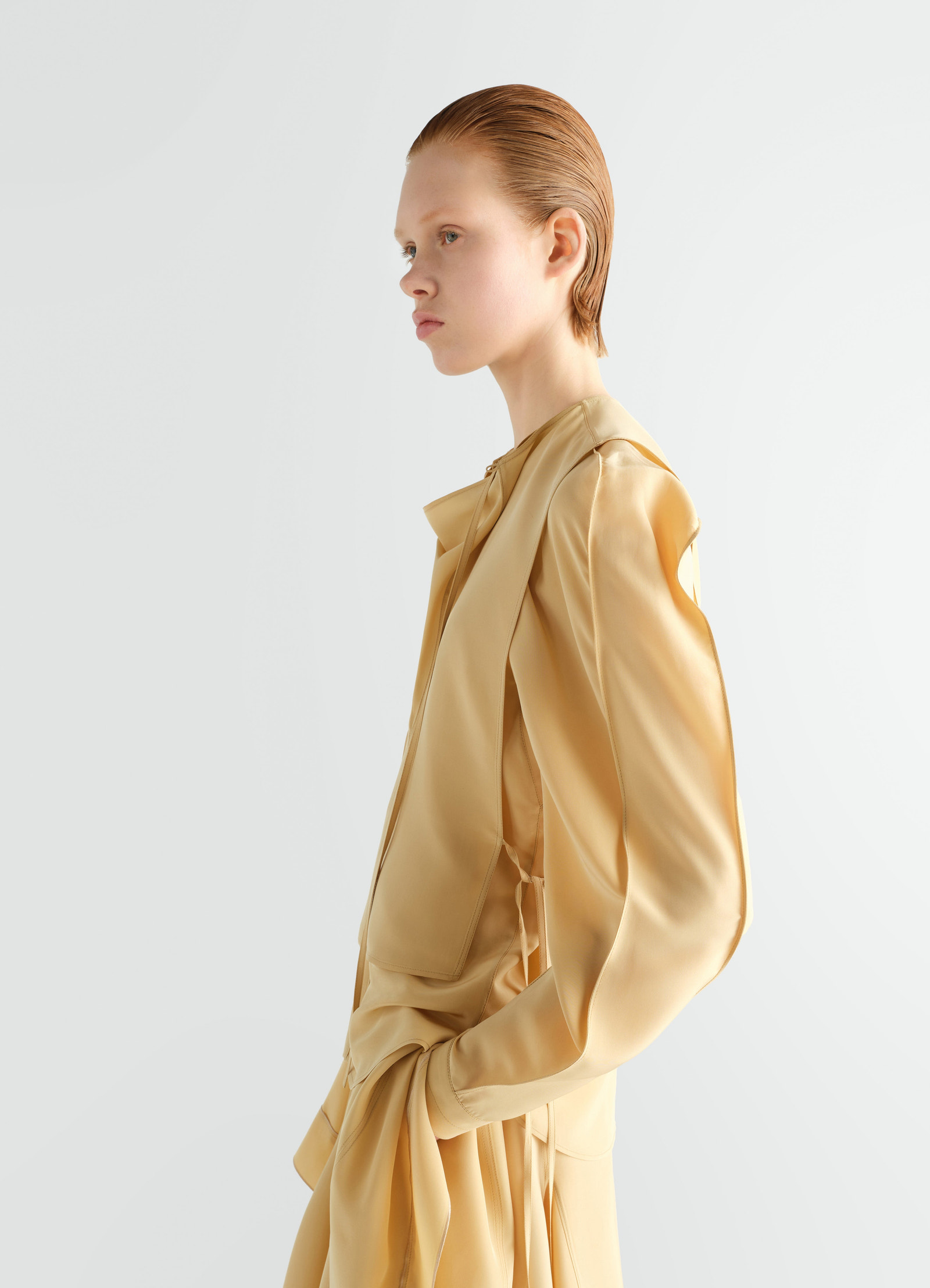 Layered yellow silk and viscose blouse by lemaire worn by a model side view with draped detail