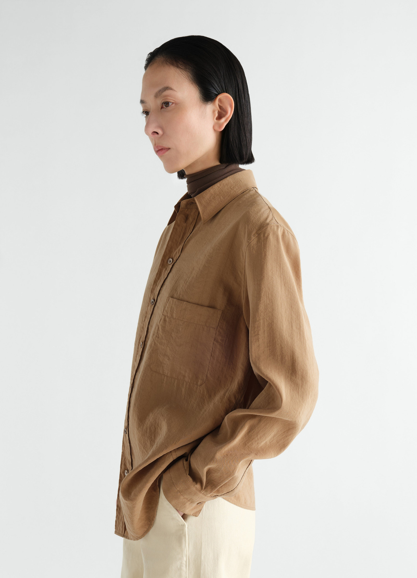 Straight shirt in brown dry silk lemaire worn by a model side view with long sleeves and chest pocket