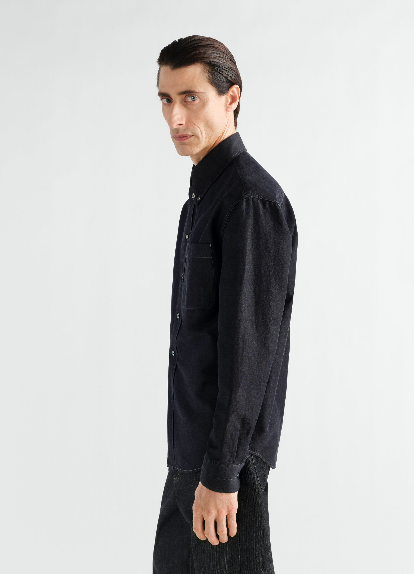 Chemise à col boutonné en chambray de lin et coton, coloris noir, porté par un mannequin, vue de profil, boutons visibles