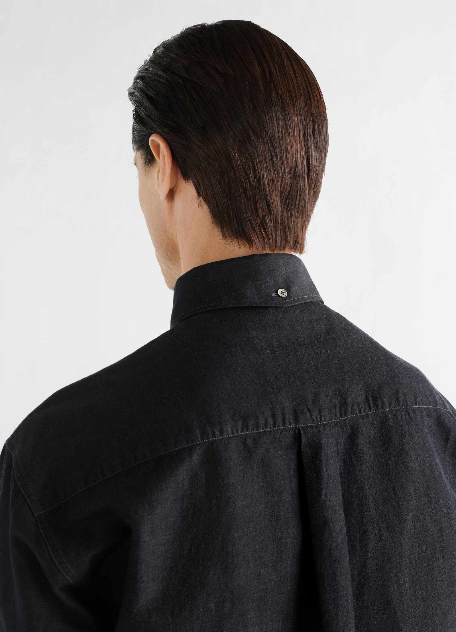 Chemise à col boutonné en chambray de lin et coton, coloris noir, porté par un mannequin, gros plan de dos, boutons visibles, col visible
