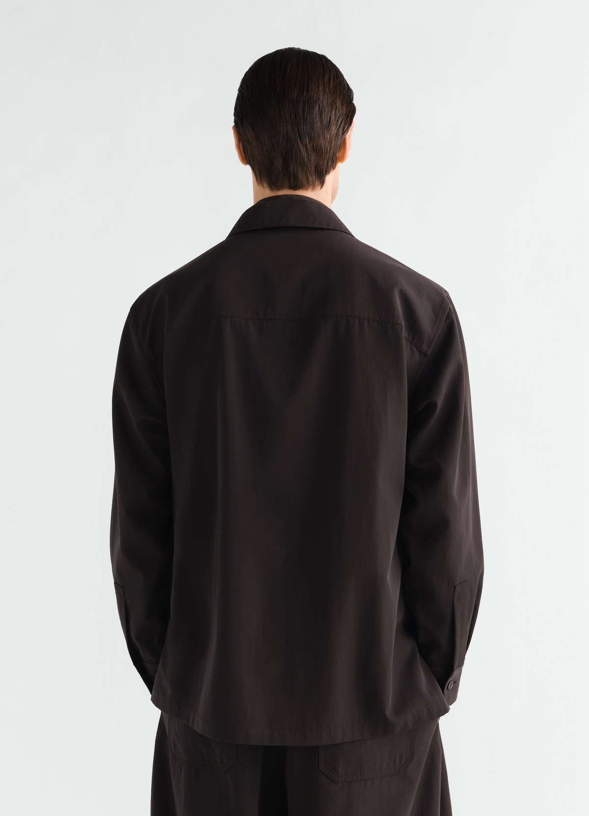Light black wool gabardine overshirt lemaire worn by a model shown from back with collar and cuffs visible