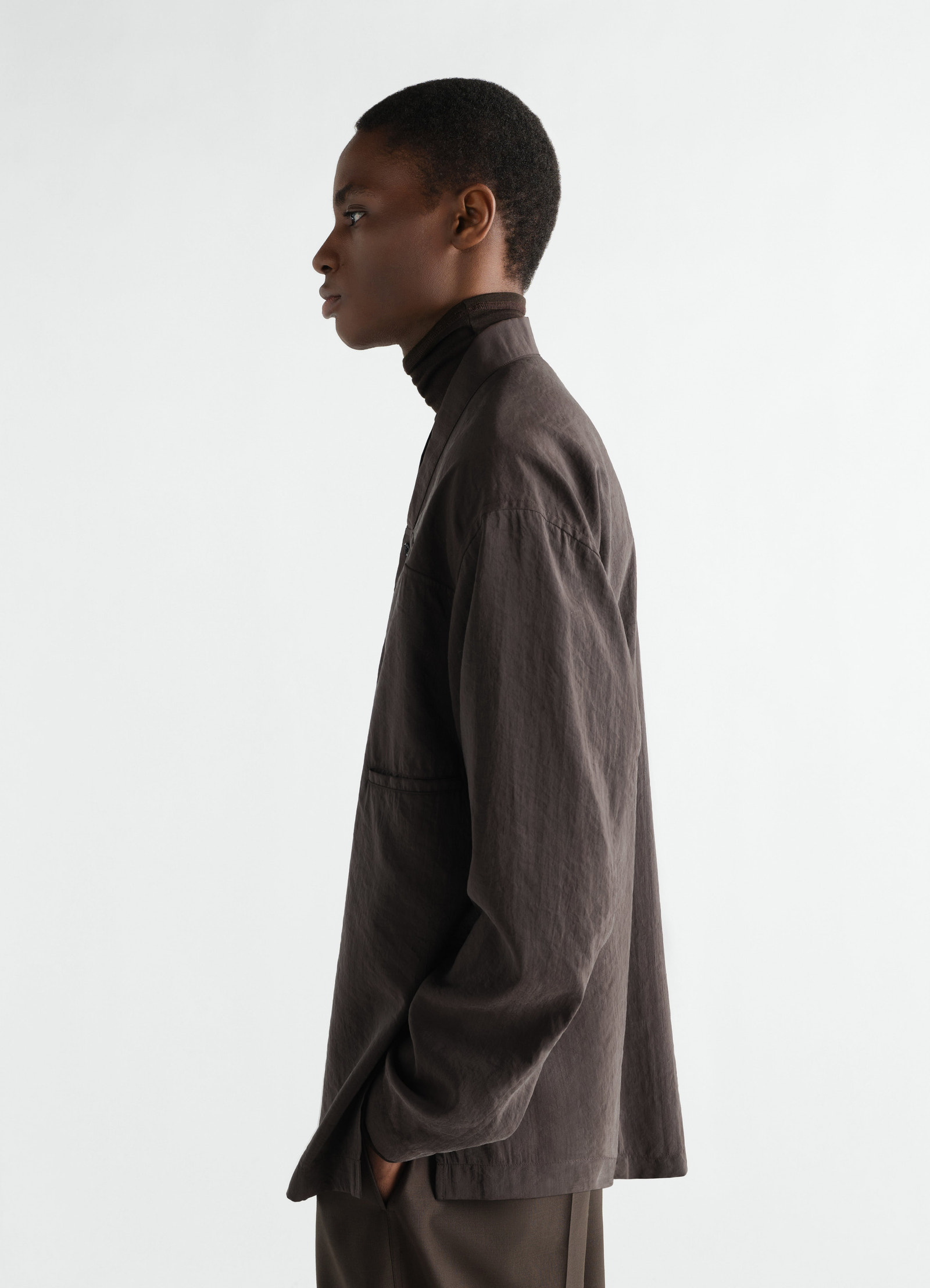 V-neck dry silk shirt in dark brown lemaire worn by model side view with long sleeves and pockets