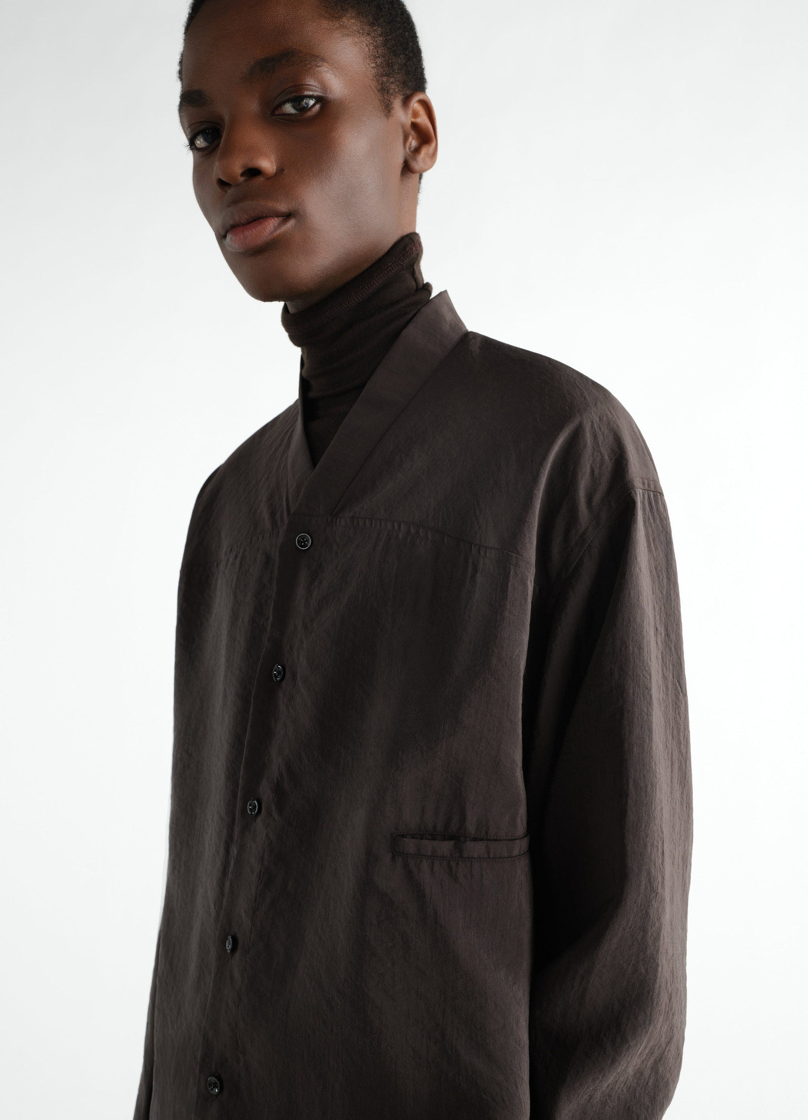 V-neck black dry silk shirt worn by model with black turtleneck lemaire front detail close-up