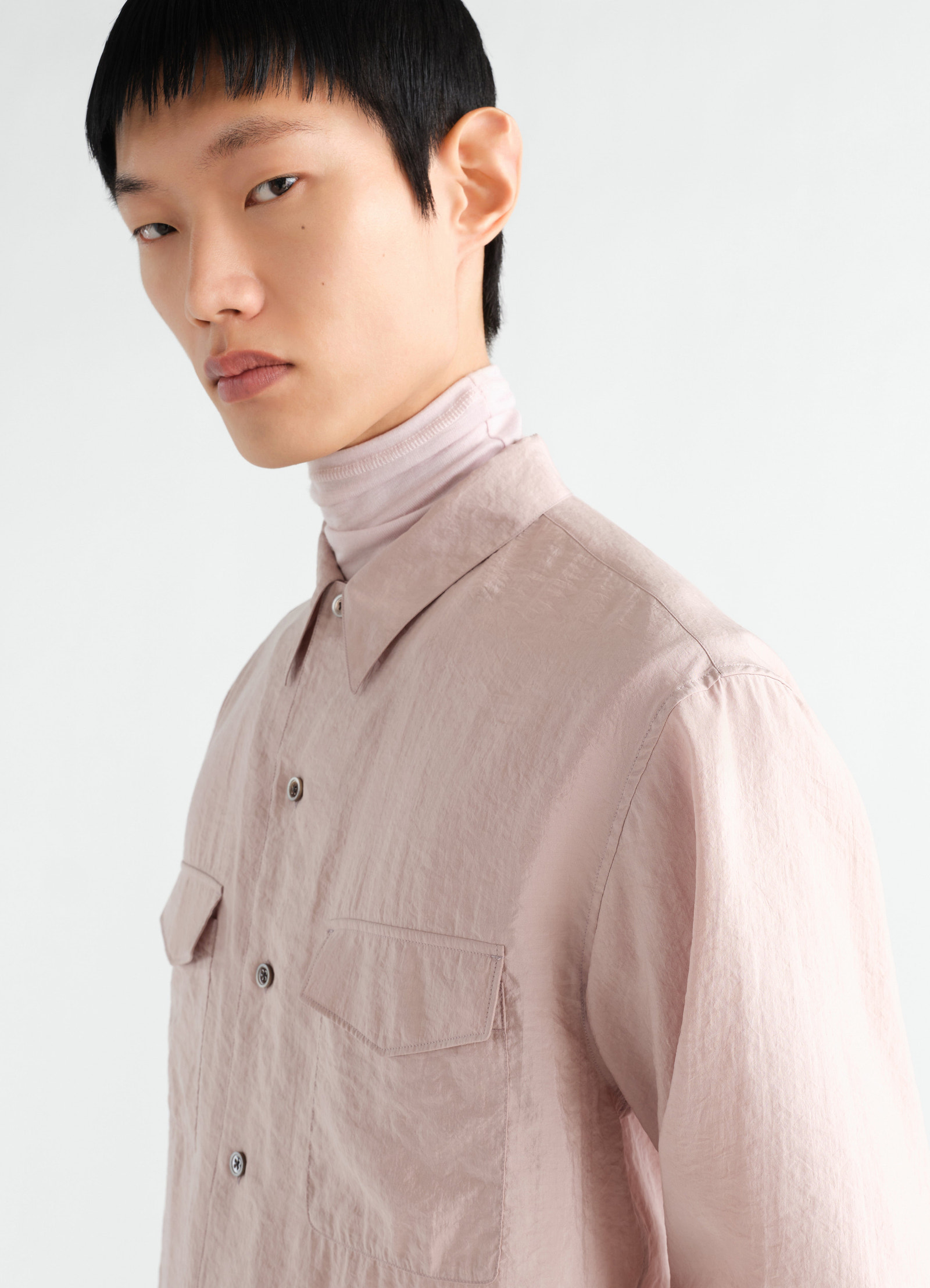 Convertible collar shirt lemaire in light pink dry silk worn by model close-up front side angle