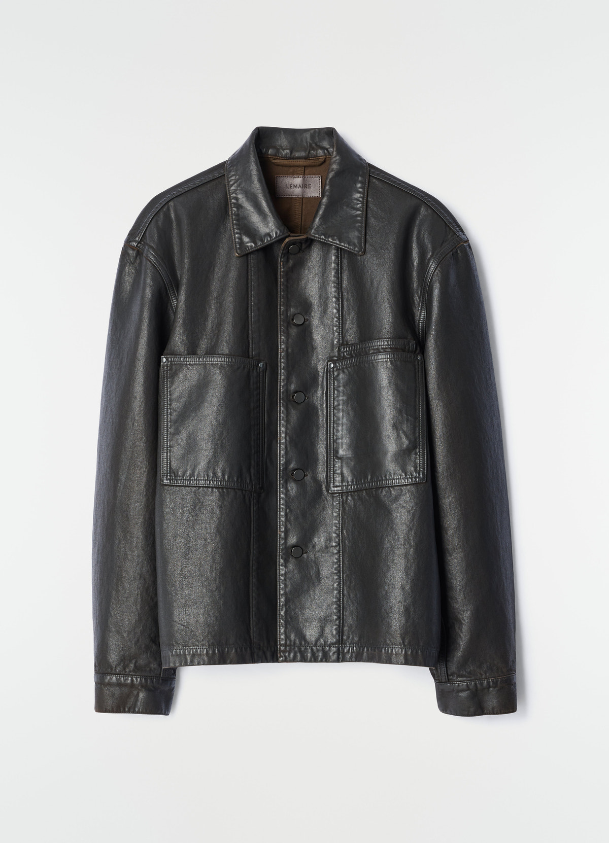 Workwear overshirt in black coated denim with front pockets by lemaire on plain white background
