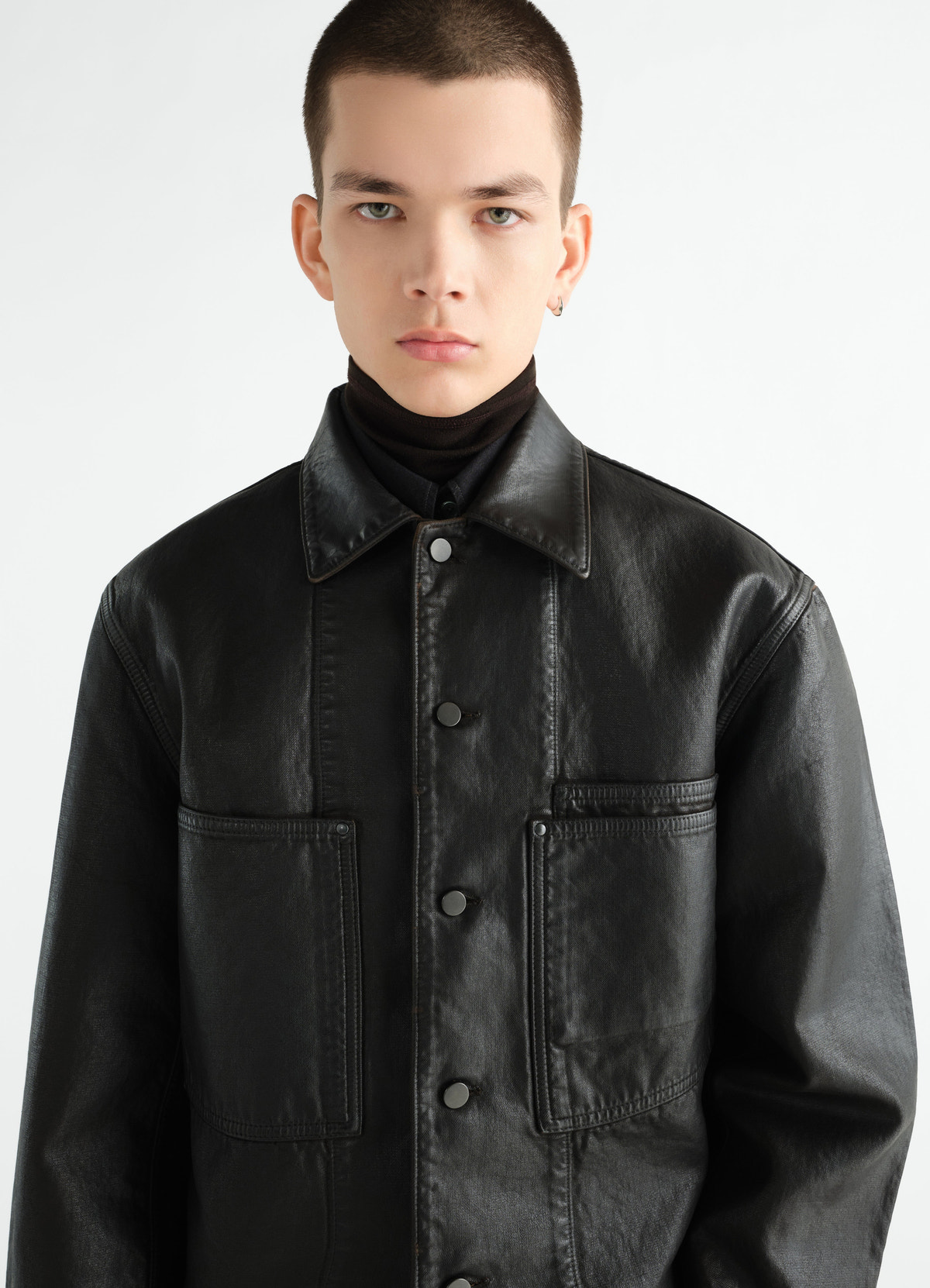 Workwear overshirt in black coated denim lemaire worn by a model front close-up detail