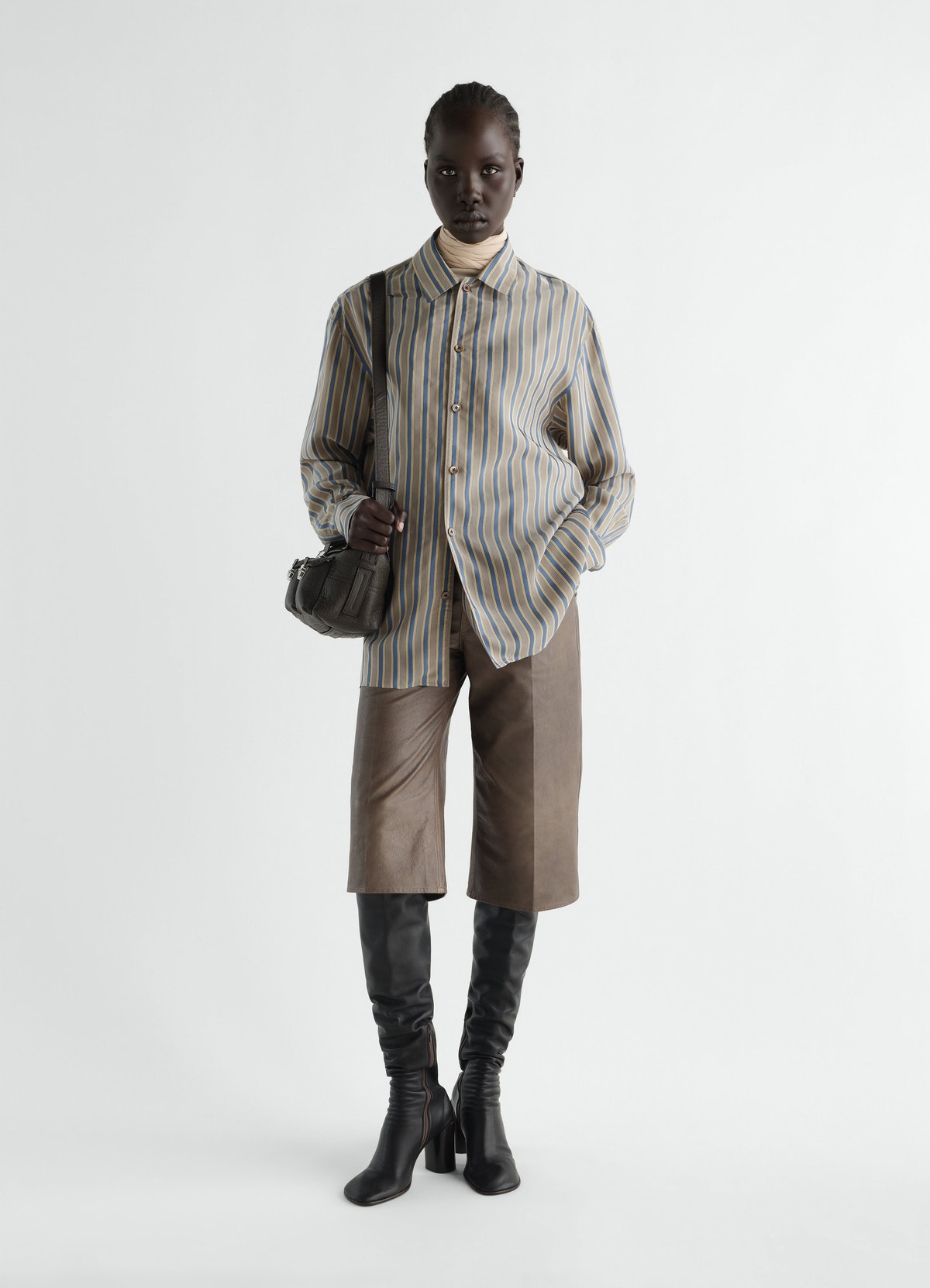 Convertible-collar striped cupro shirt in beige and blue by lemaire worn by model, front view with leather shorts and black