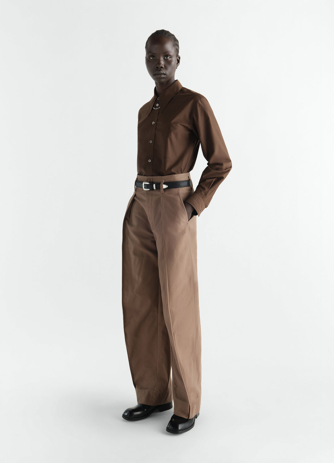 Pointed collar brown cotton silk shirt by LEMAIRE worn by model with high-waisted beige trousers front view