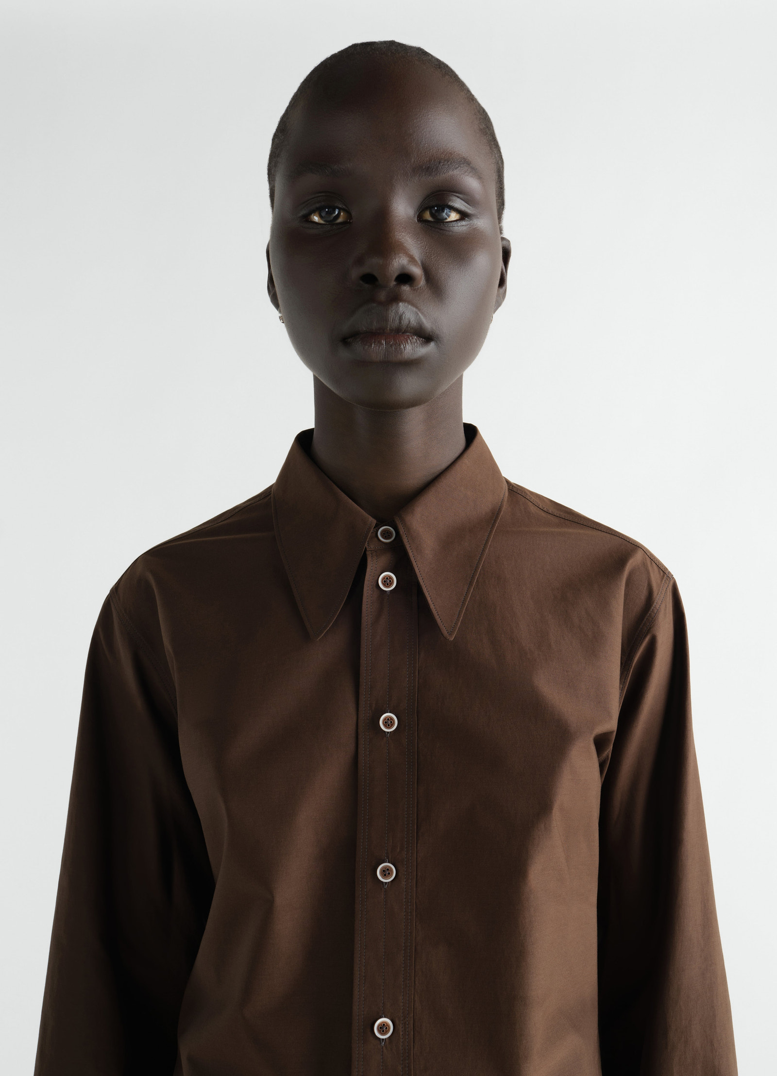 Pointed collar brown washed cotton silk shirt by lemaire worn by model front view close-up