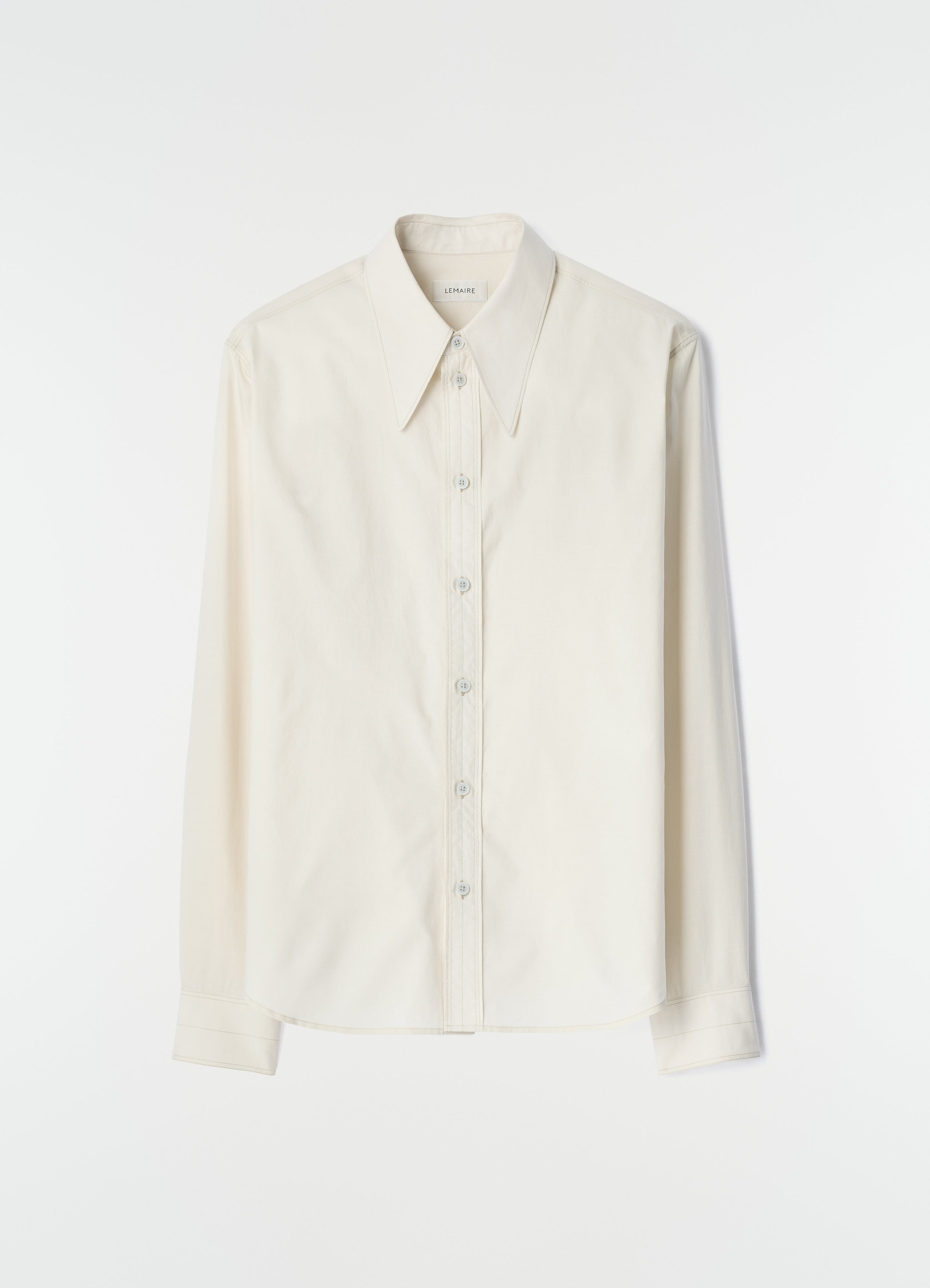 Pointed collar off-white washed cotton silk shirt by lemaire flat lay on white background front view