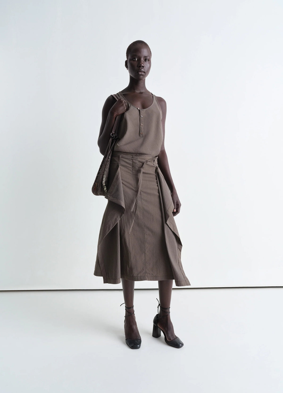 Convertible Skirt in Technical Lyocell, model shot, Front view Draping panel detail