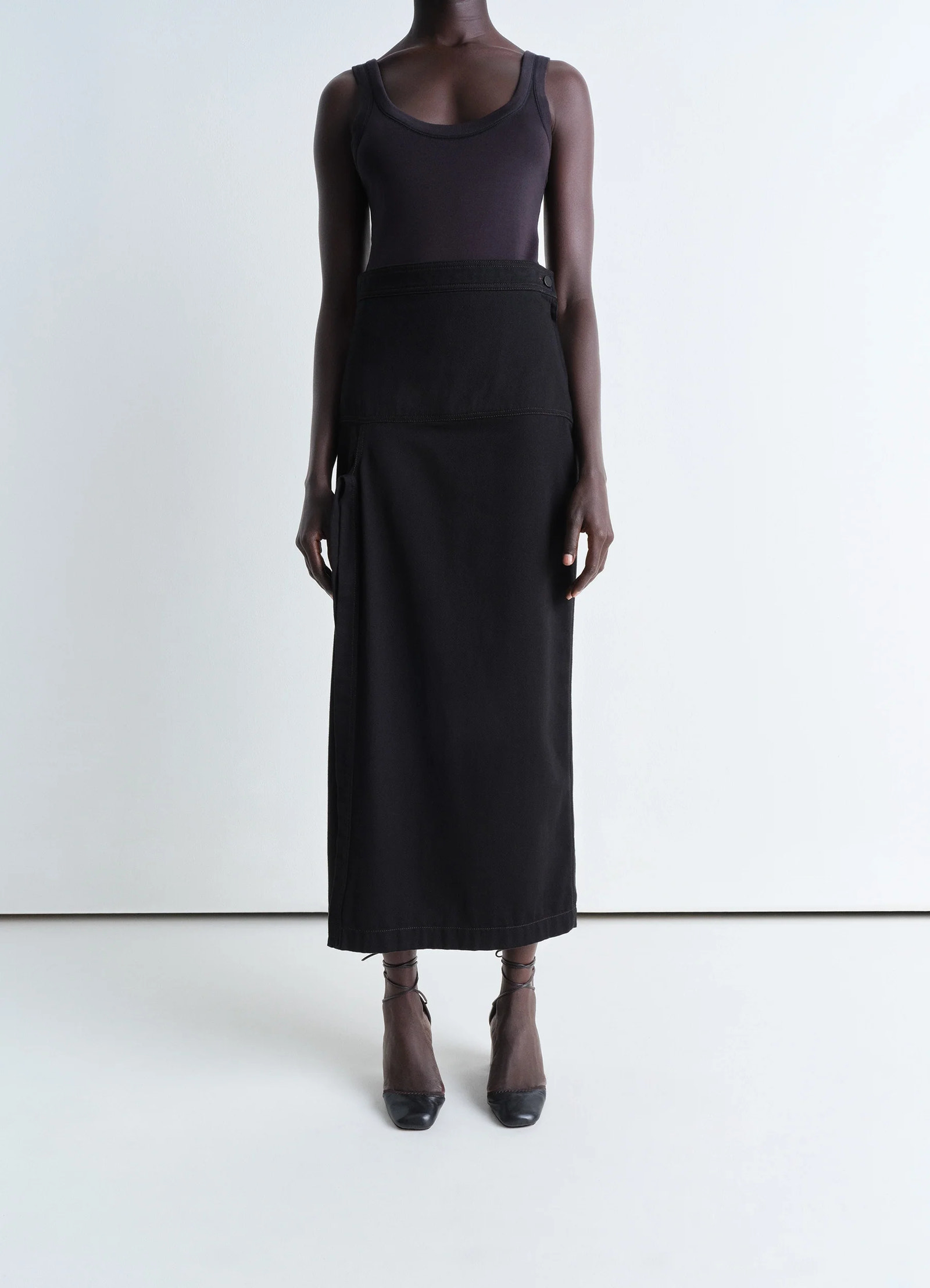 Lemaire asymmetrical wrap skirt in black cotton denim, model shot, front pose view high waist, straight cut