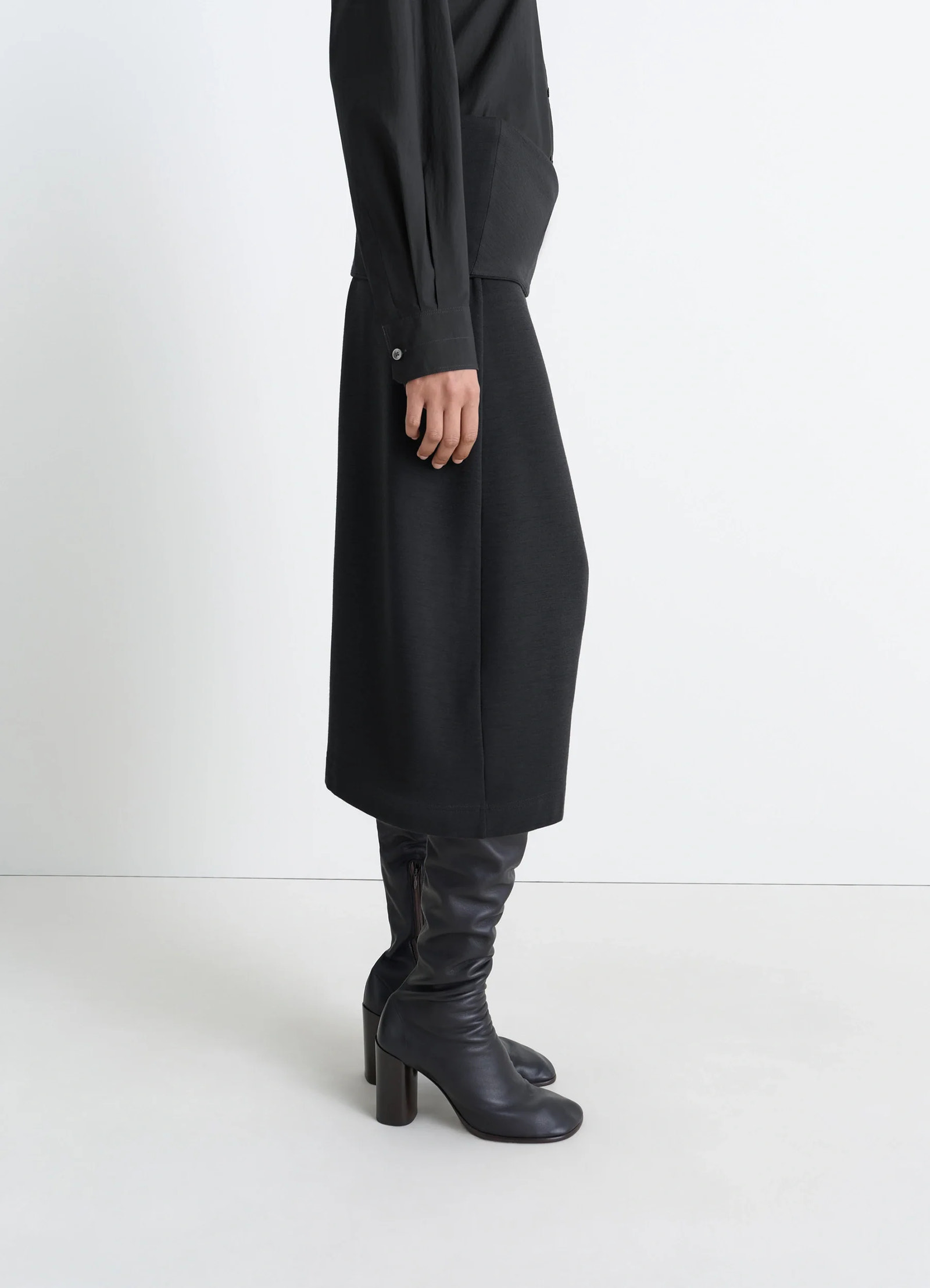Lemaire twisted hem dress in black wool viscose-blend, model shot, three-quarter view draped fabric profile