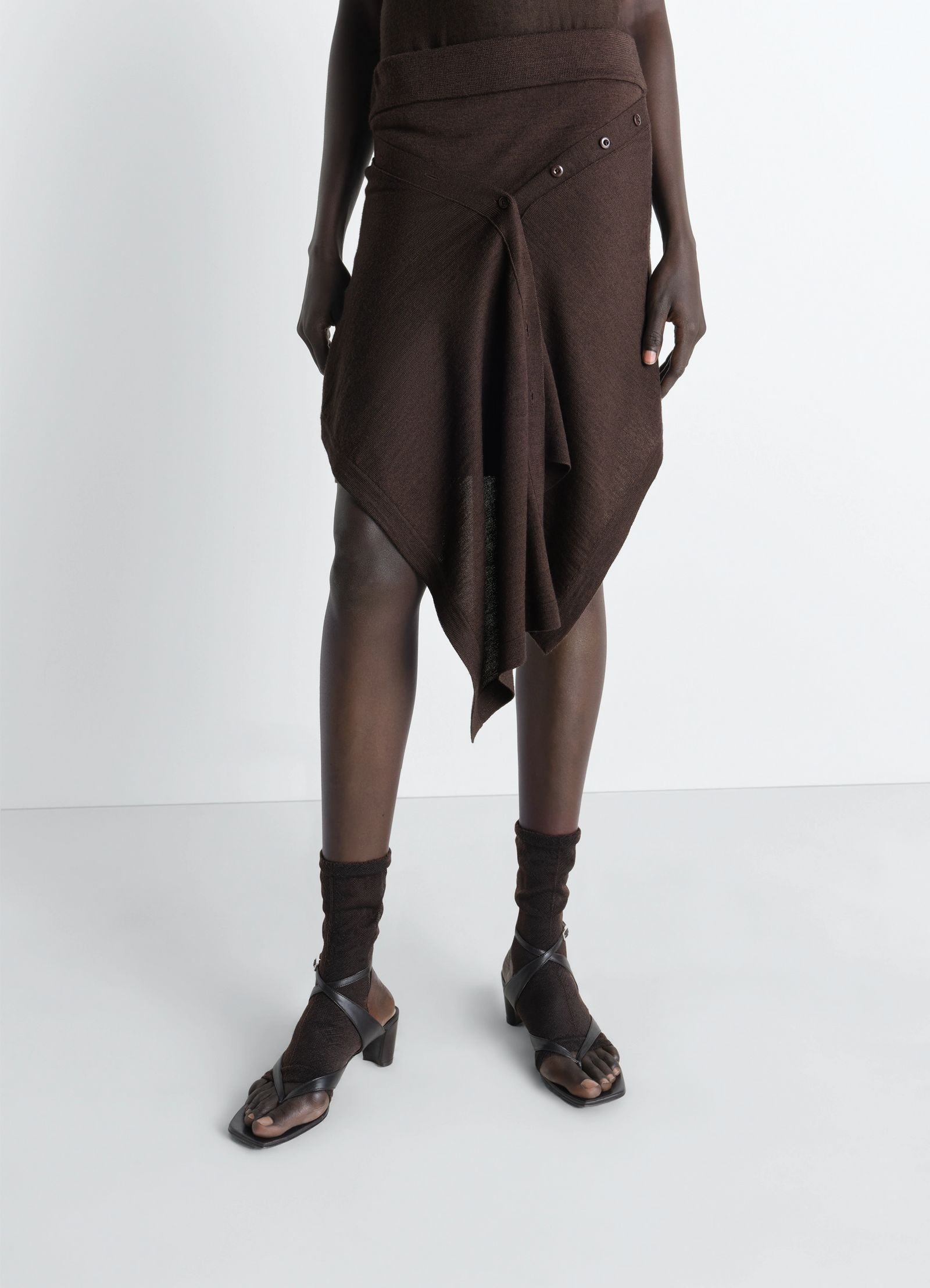 Lemaire buttoned skirt in merino wool blend, model shot, side view asymmetrical hem