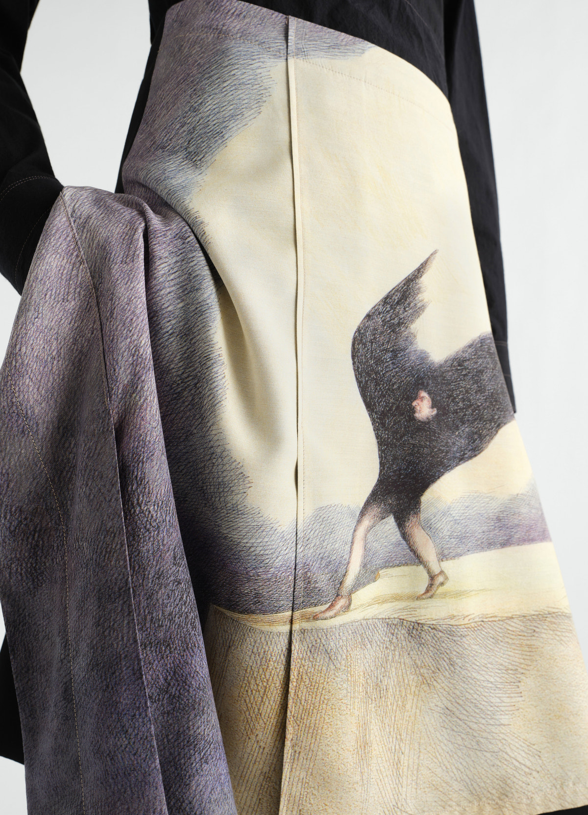 Jupe en toile de laine imprimée "la nuit qui marche", coloris noir, porté par un mannequin, gros plan, motif imprimé visible