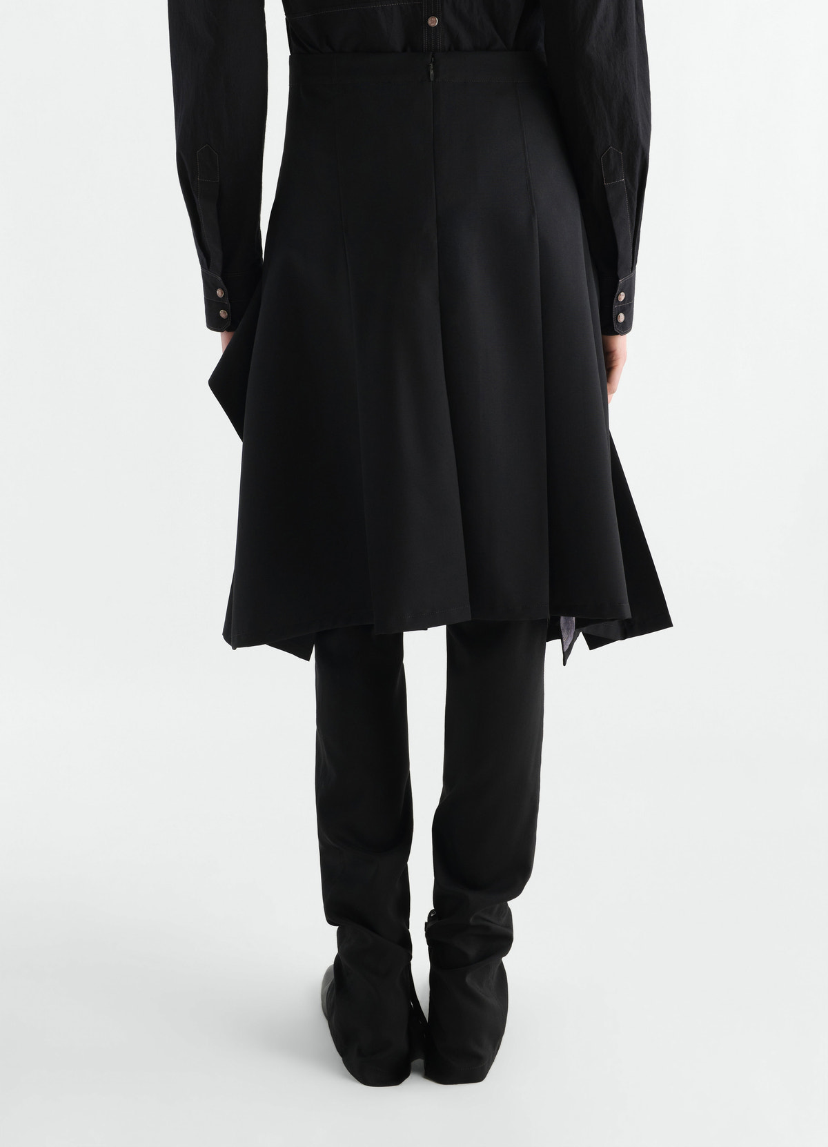 Jupe en toile de laine imprimée "la nuit qui marche", coloris noir, porté par un mannequin, vue de dos, coupe asymétrique, motif imprimé visible