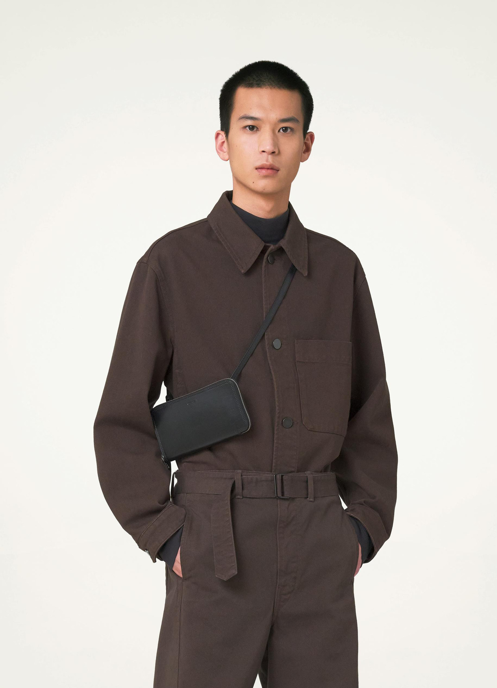 Continental wallet with strap in vegetable-tanned buffalo leather, model shot, worn crossbody view minimalist design, casual