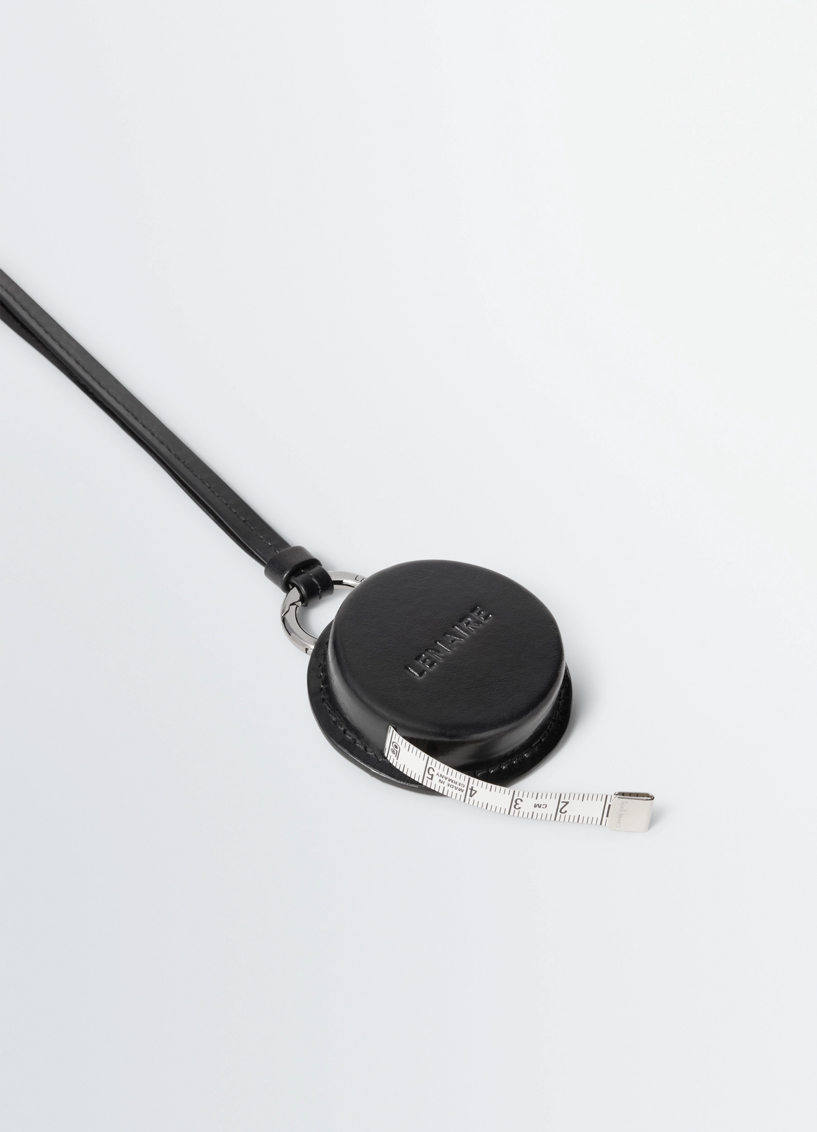 Molded tape necklace in silver lwg-certified leather, product shot, diagonal top view embossed logo detail