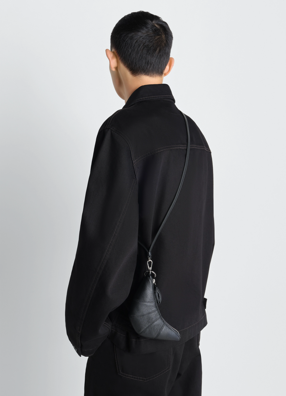 Cross-Body Croissant Coin Purse in Grained Leather, model shot, back view curved stitching detail