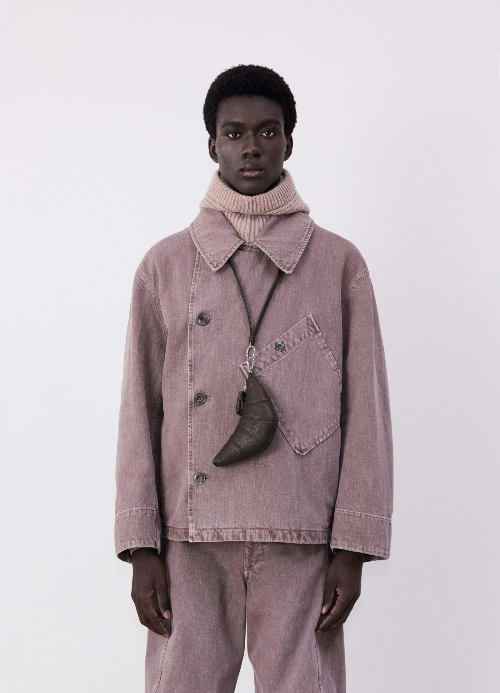 Cross-body croissant coin purse in soft grained leather, model shot, front worn hanging on neck