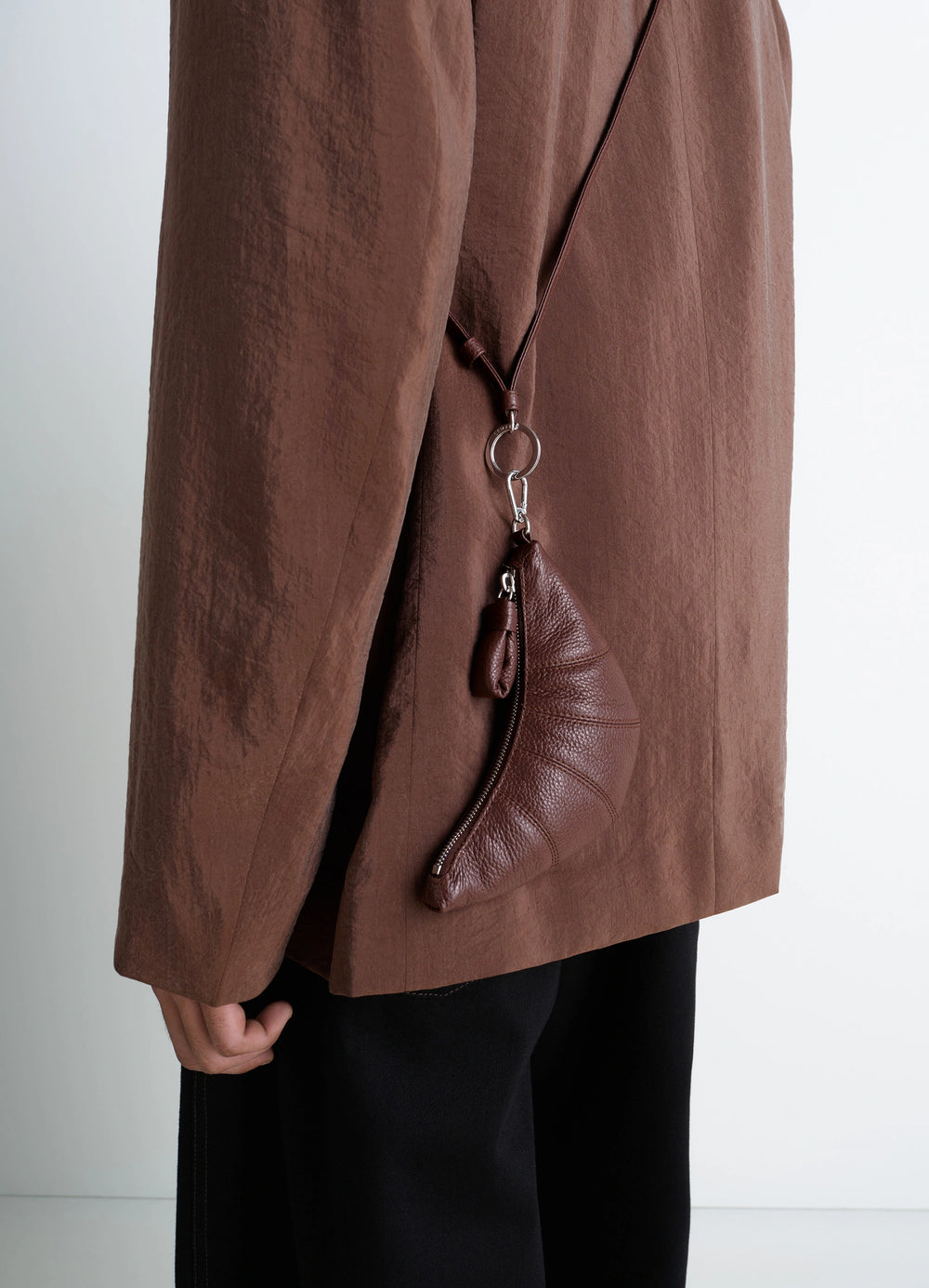 CROSSBODY CROISSANT COIN PURSE in grained leather, model shot, side view half-moon shape