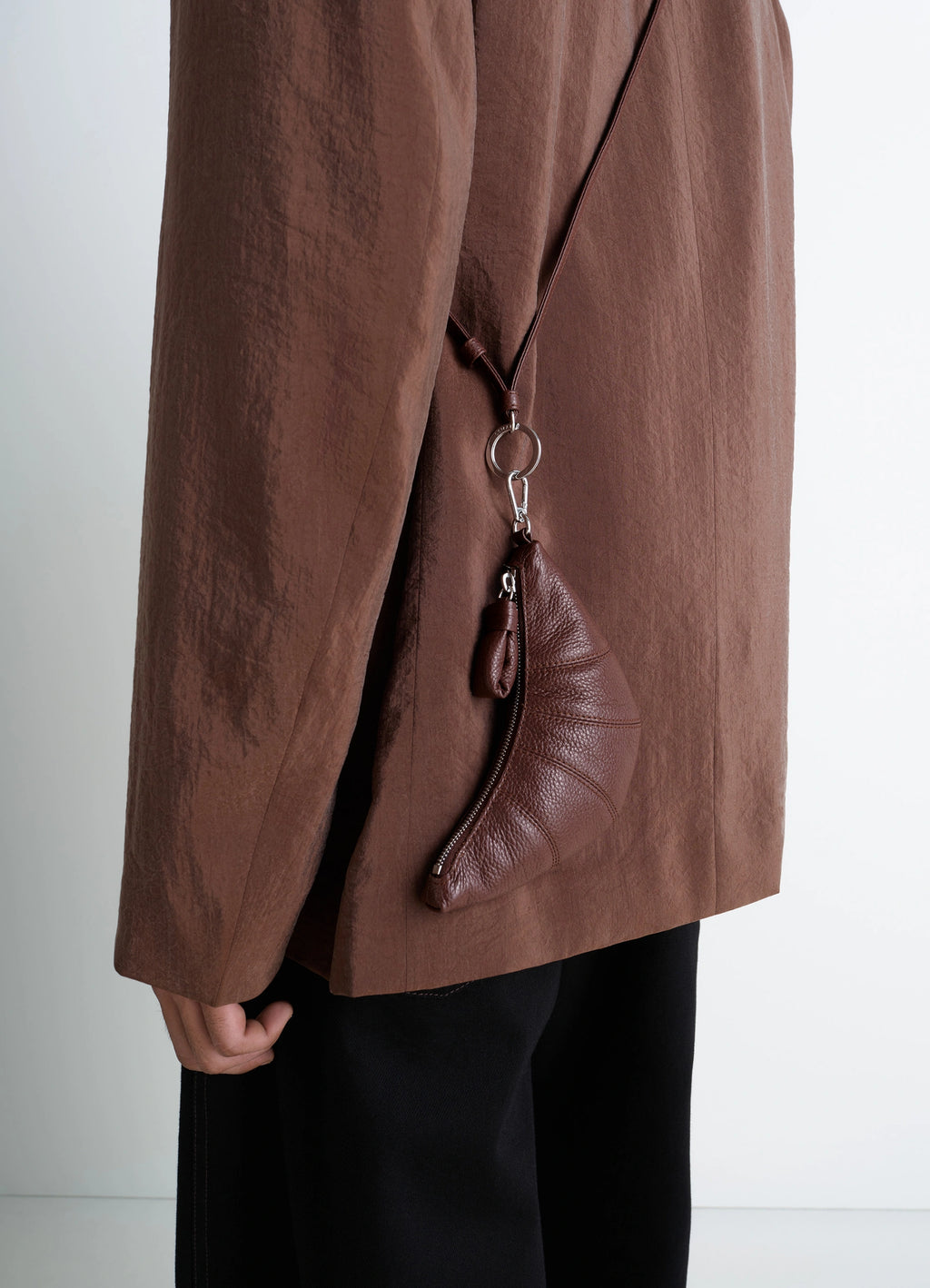 CROSSBODY CROISSANT COIN PURSE in grained leather, model shot, side view half-moon shape