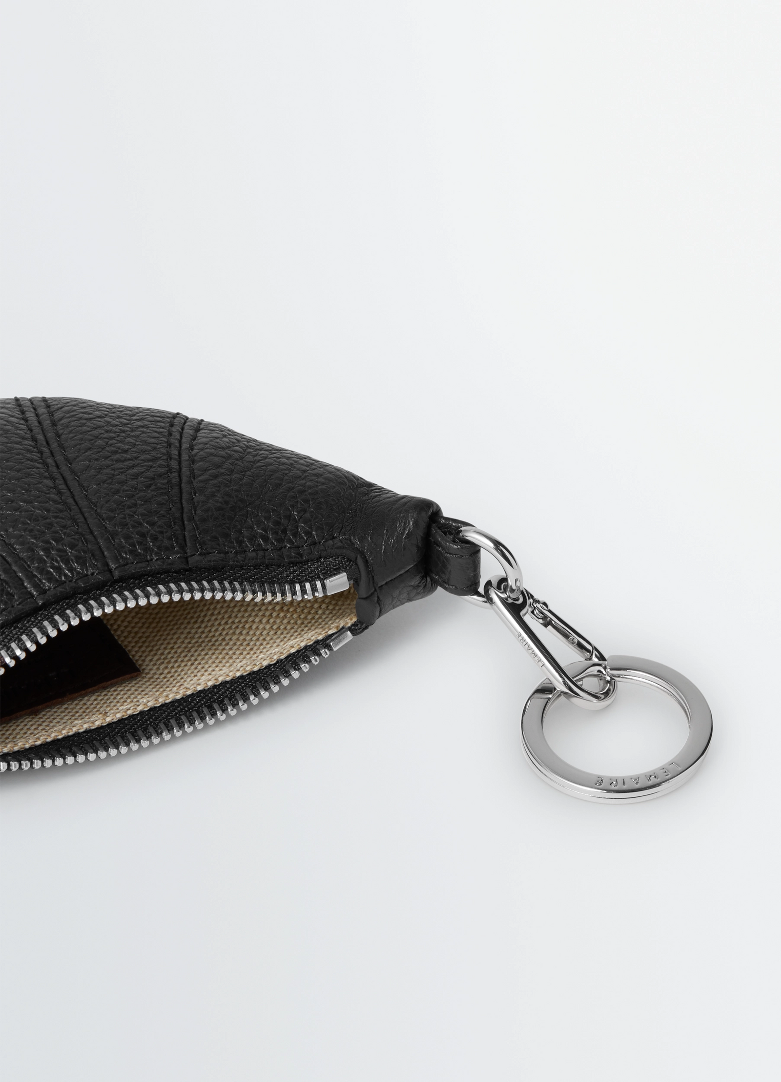 Mini croissant keyring in black grained leather, product shot, detail shot of zipper textured leather finish