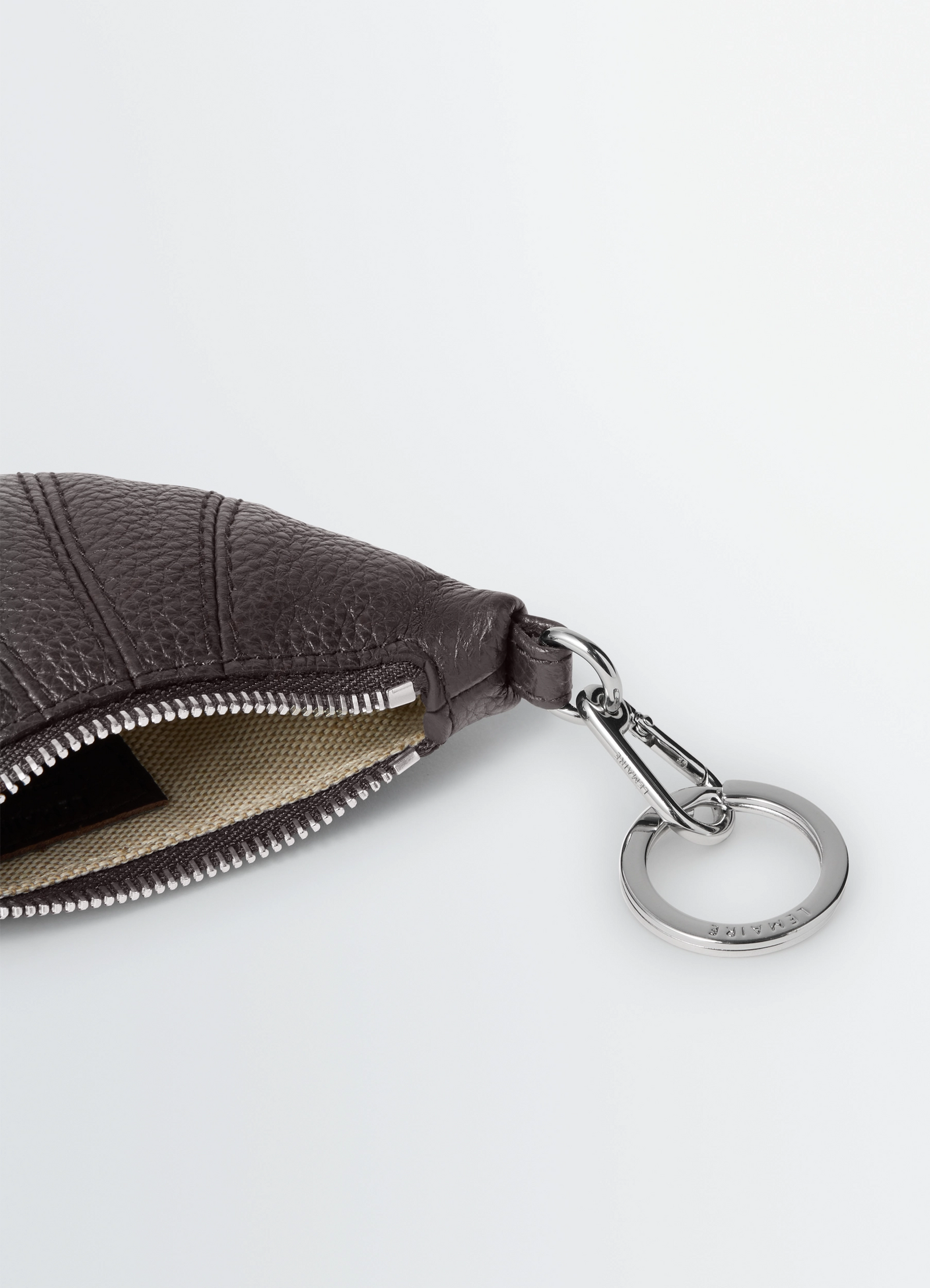Mini croissant keyring in grained leather, product shot, close-up detail zipper and keyring focus