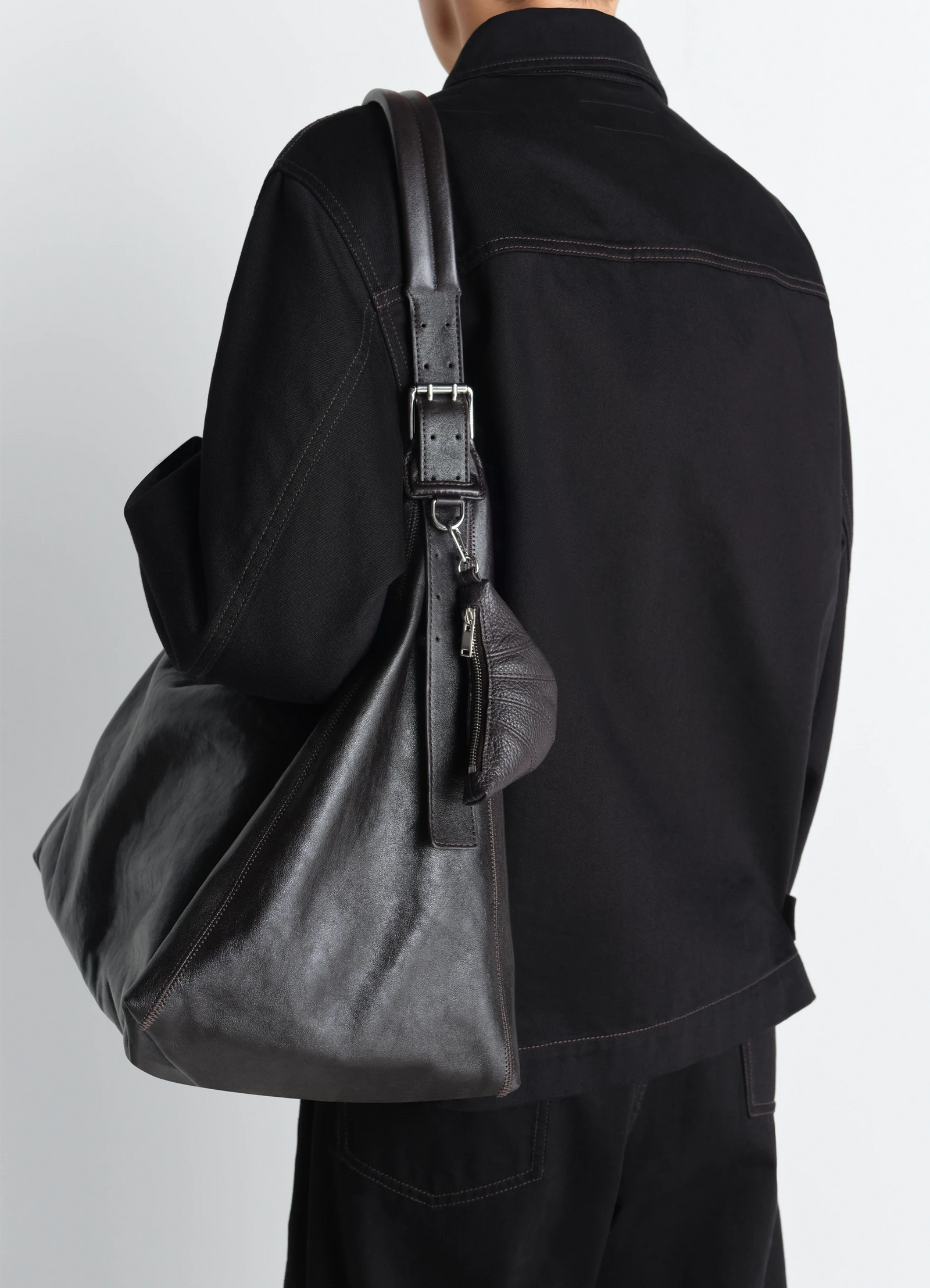 Mini croissant keyring in grained leather, model shot, back view hanging on bag