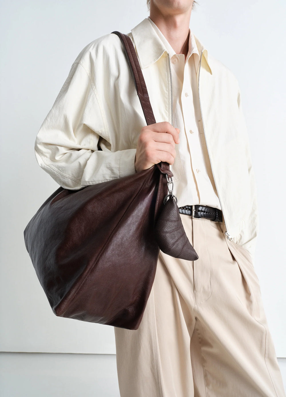 Mini Croissant Keyring in Grained Leather, model shot, detail shot attached to bag