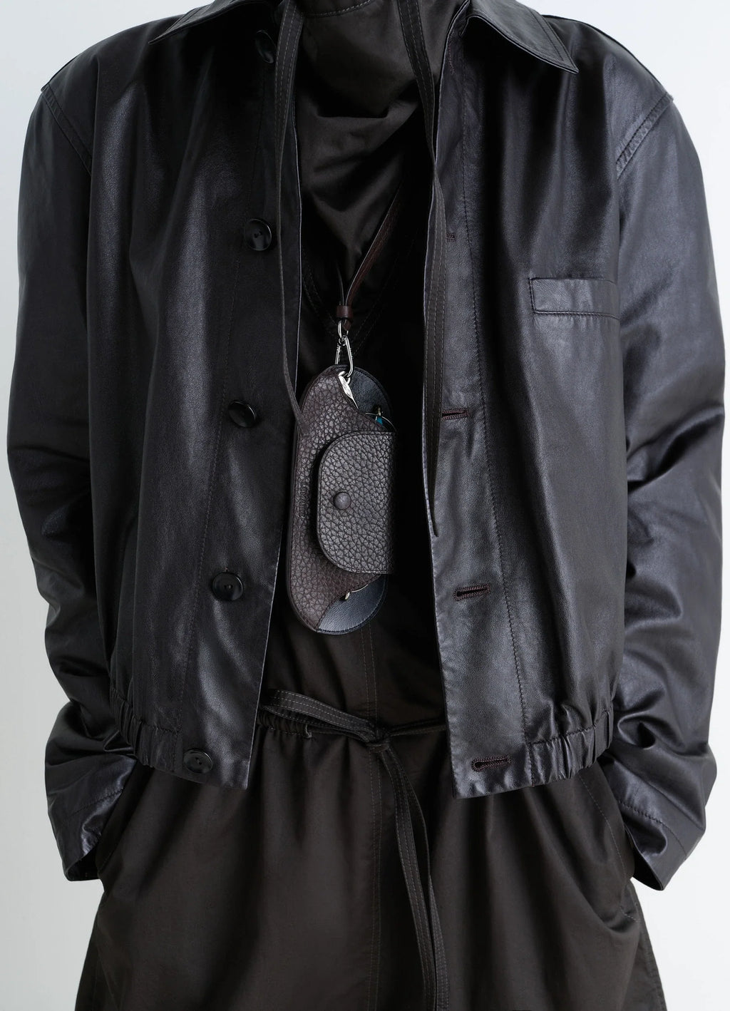 BELL GLASSES HOLDER in Grained Leather, model shot, detail shot hanging on neck strap