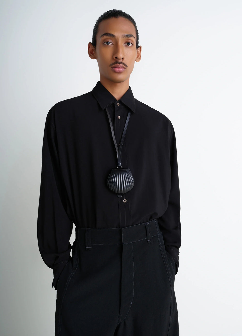Carlos Shell Coin Purse Necklace in Black Vegetable-tanned Leather, model shot, side view worn by model