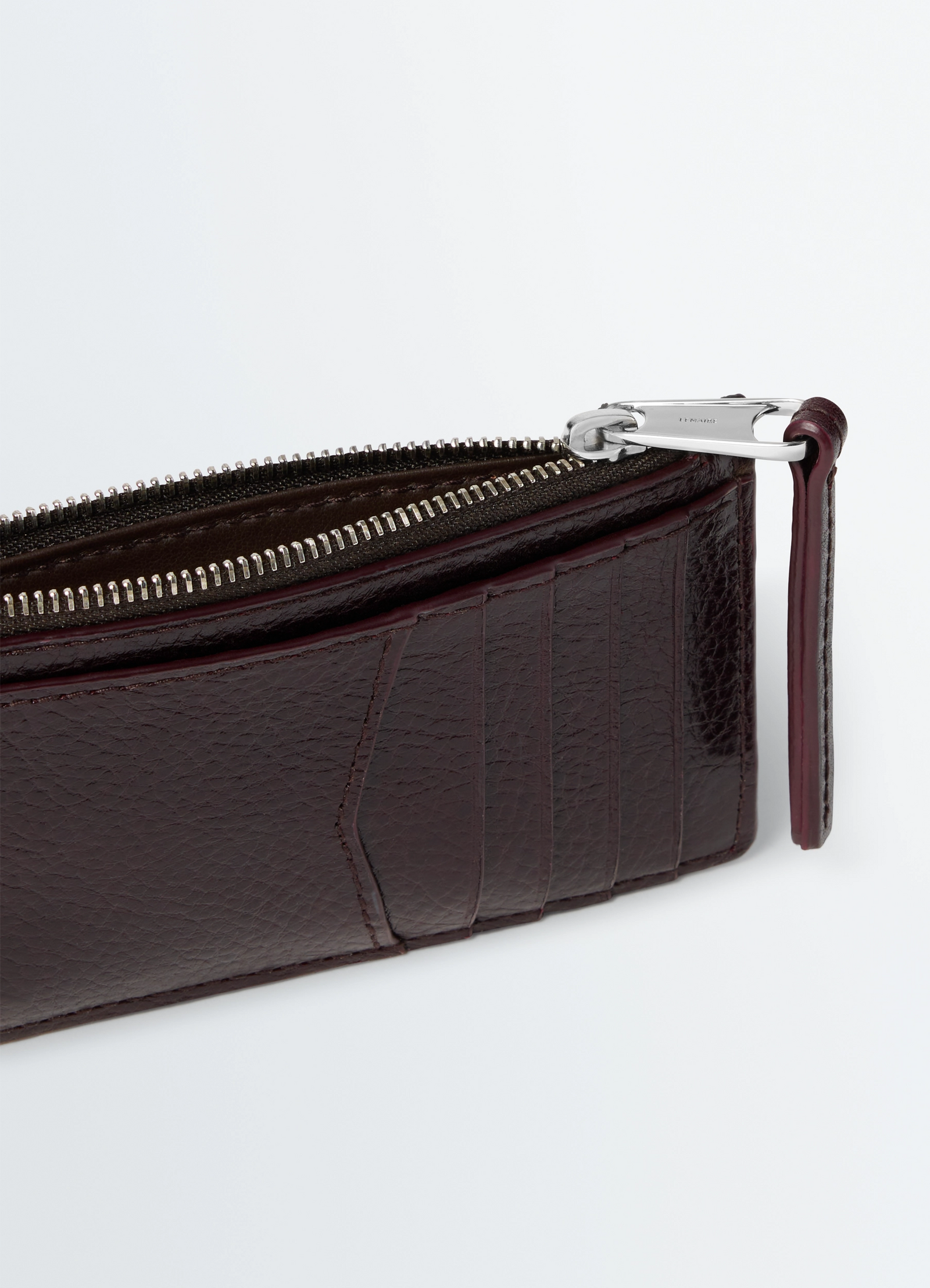 Gear card holder and coin purse in glossy vegetable-tanned leather, product shot, top corner view visible card slots and zipp