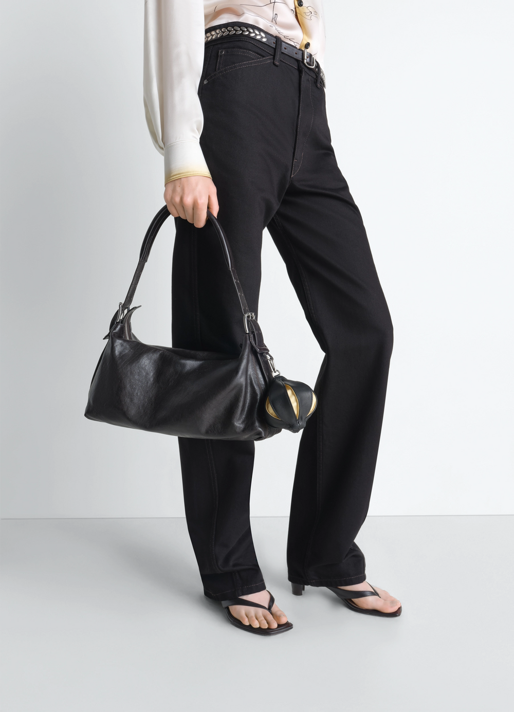 Balloon Bag Charm in Black Leather, model shot, side view held by handle