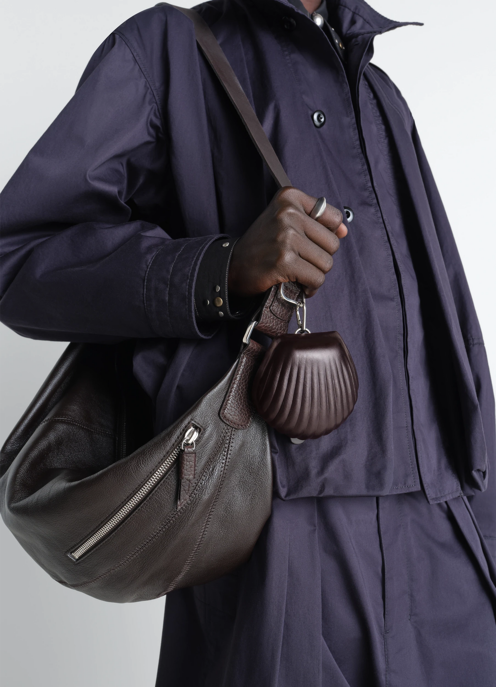 Carlos shell key ring in leather, model shot, profile view held with bag