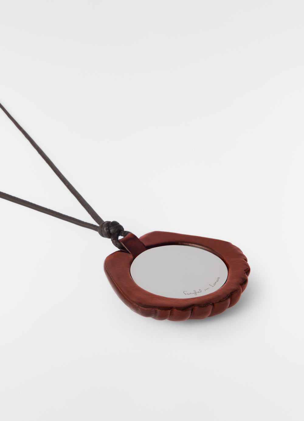 Shell mirror pendant in brown patinated calfskin with black cord LEMAIRE close-up detail on white background