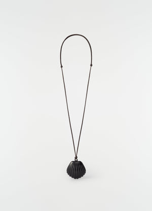 Shell mirror pendant in black patinated calfskin on long cord by lemaire on plain white background