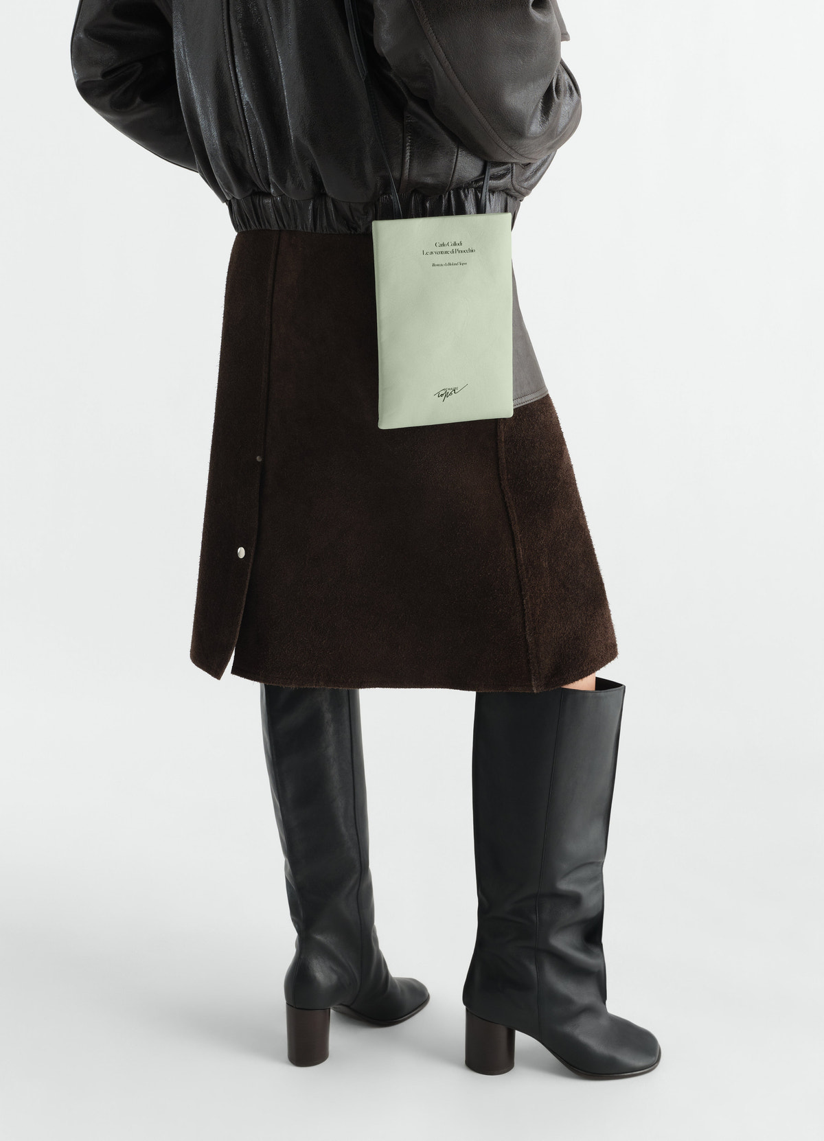 Medium book pouch in printed light green nappa leather by lemaire worn by model with dark skirt and black boots side view