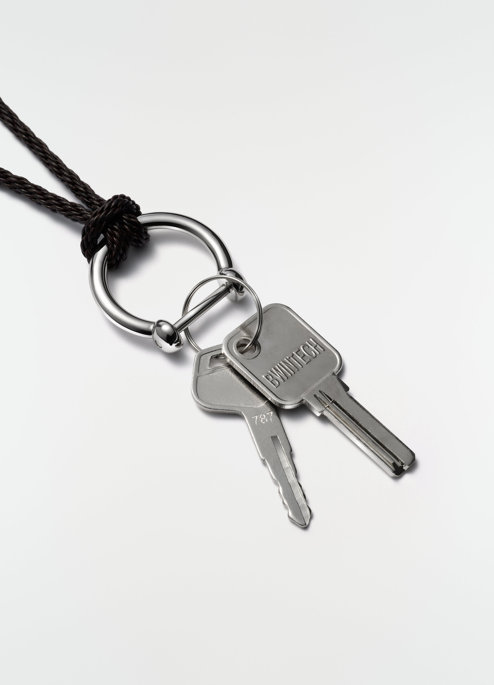 Keyring necklace with silver steel keys and braided black recycled leather cord worn by model lemaire