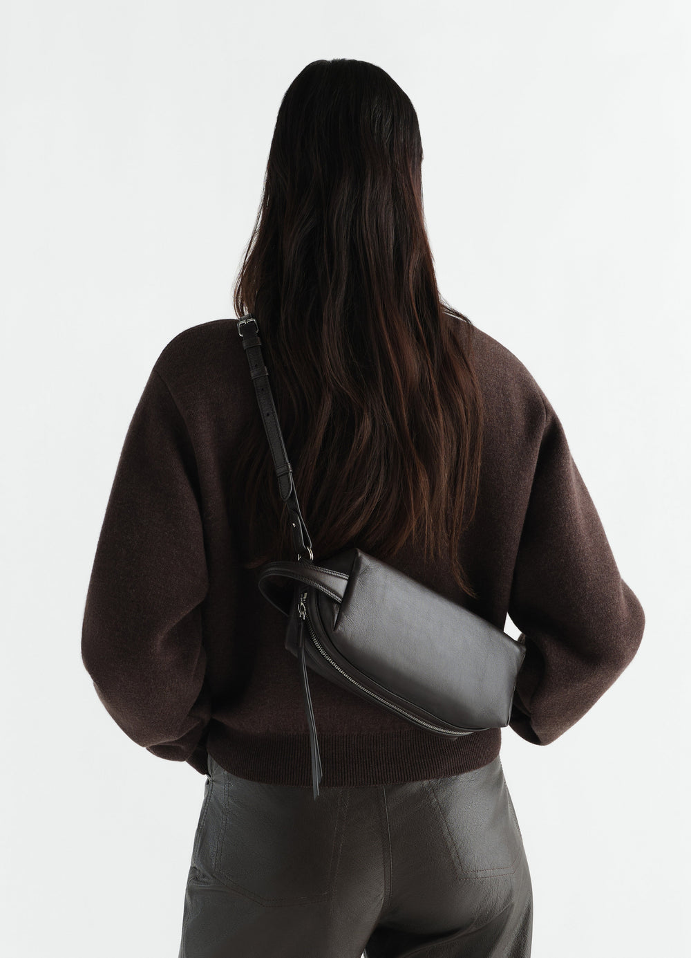 Sac care petit modèle en cuir d'agneau nappa, coloris noir, porté par un mannequin