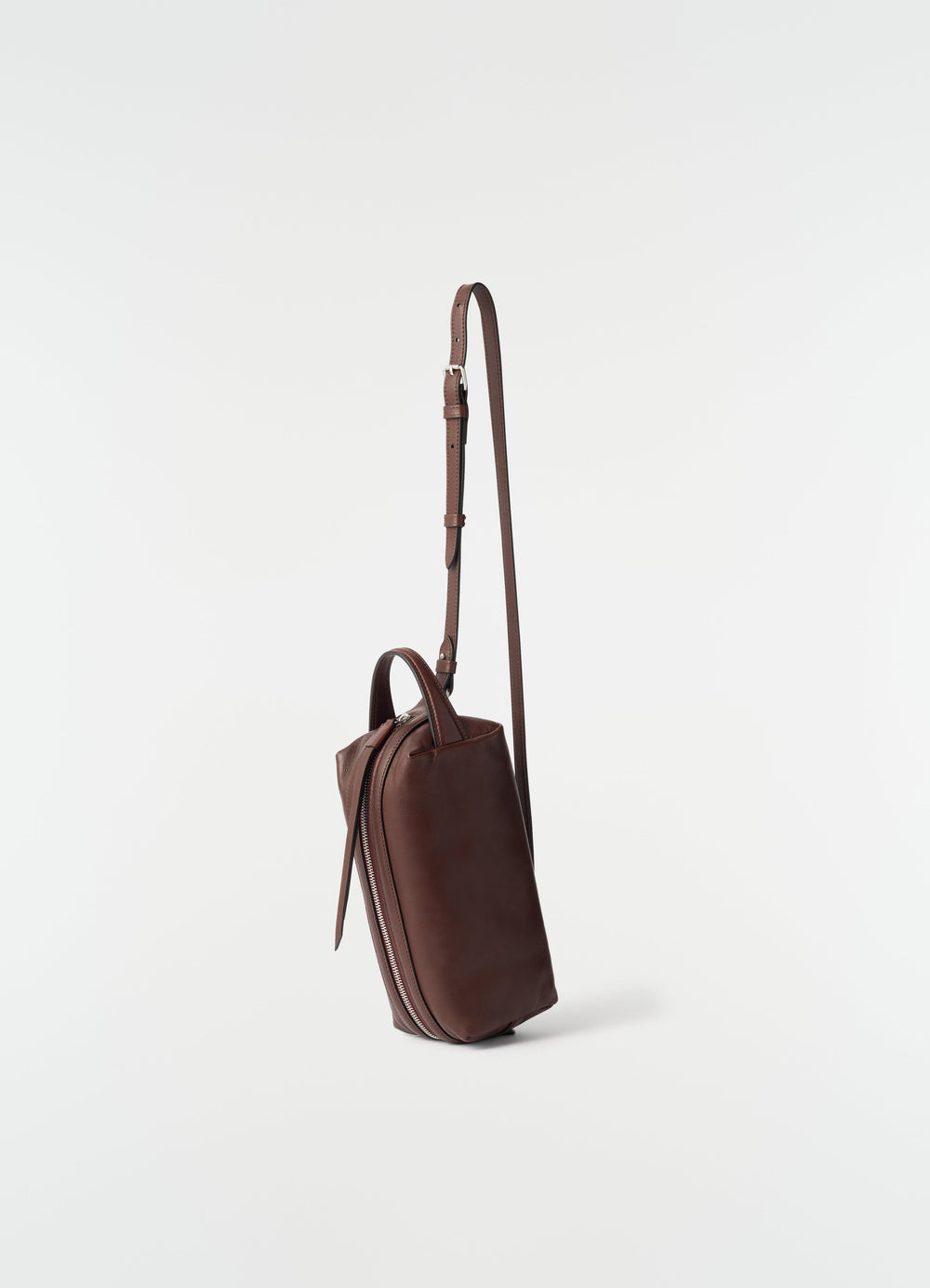 Small dark brown nappa lambskin Care Bag by LEMAIRE side view with adjustable strap on plain white background