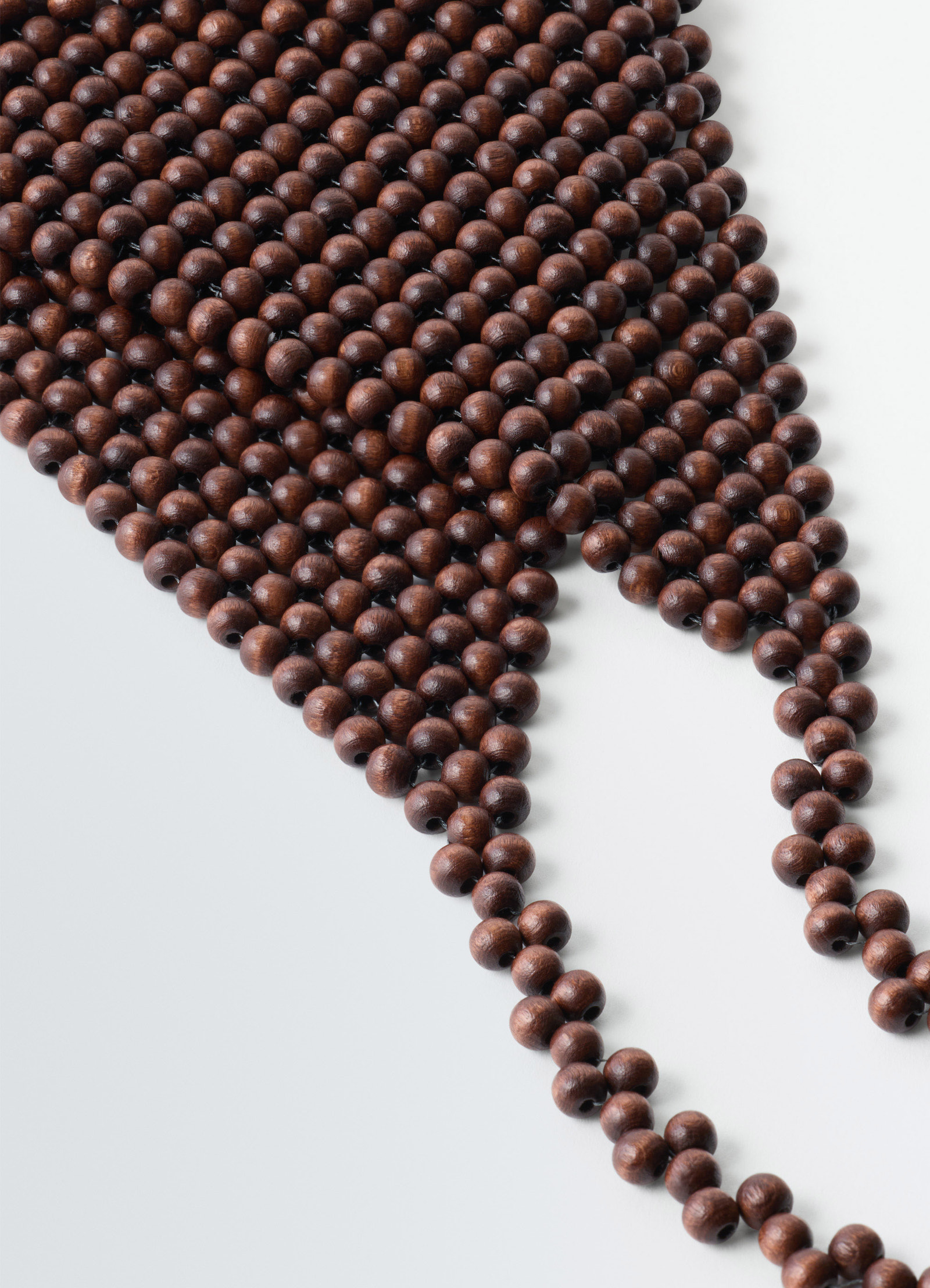 Wooden beads bandana necklace in wooden beads in neutral tones, product shot, angled close-up view interlaced bead pattern