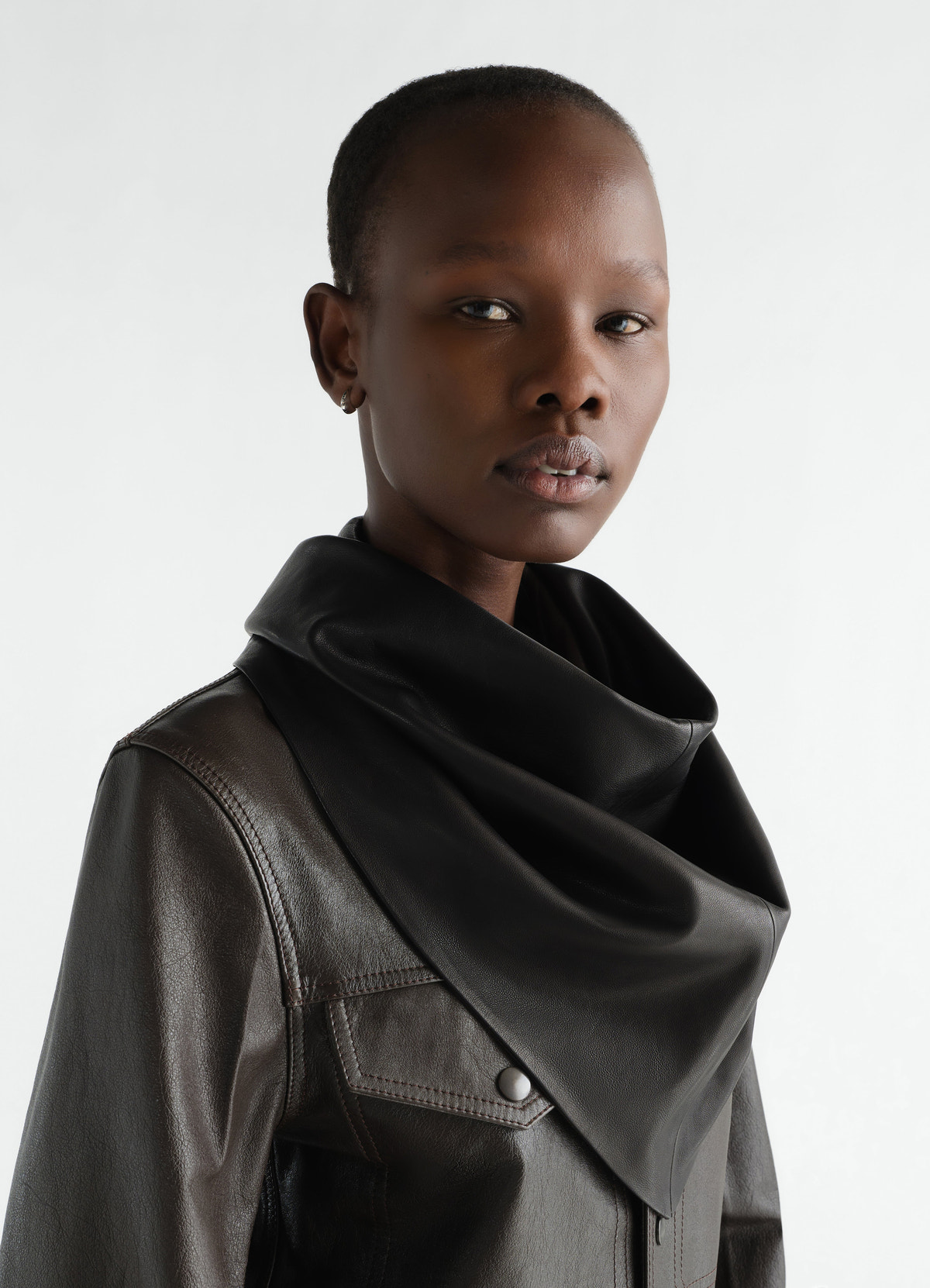 Leather black triangle scarf by lemaire worn by a model, close-up front detail on collar